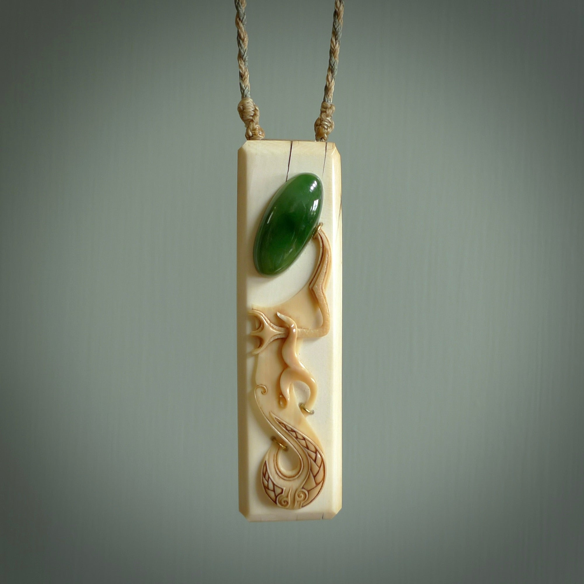 A beautiful, large toki with manaia pendant handmade from woolly mammoth tusk with Jade insert by Sami. Hand carved mammoth tusk toki manaia pendant, provided with an adjustable tan cord. Manaia head earring.