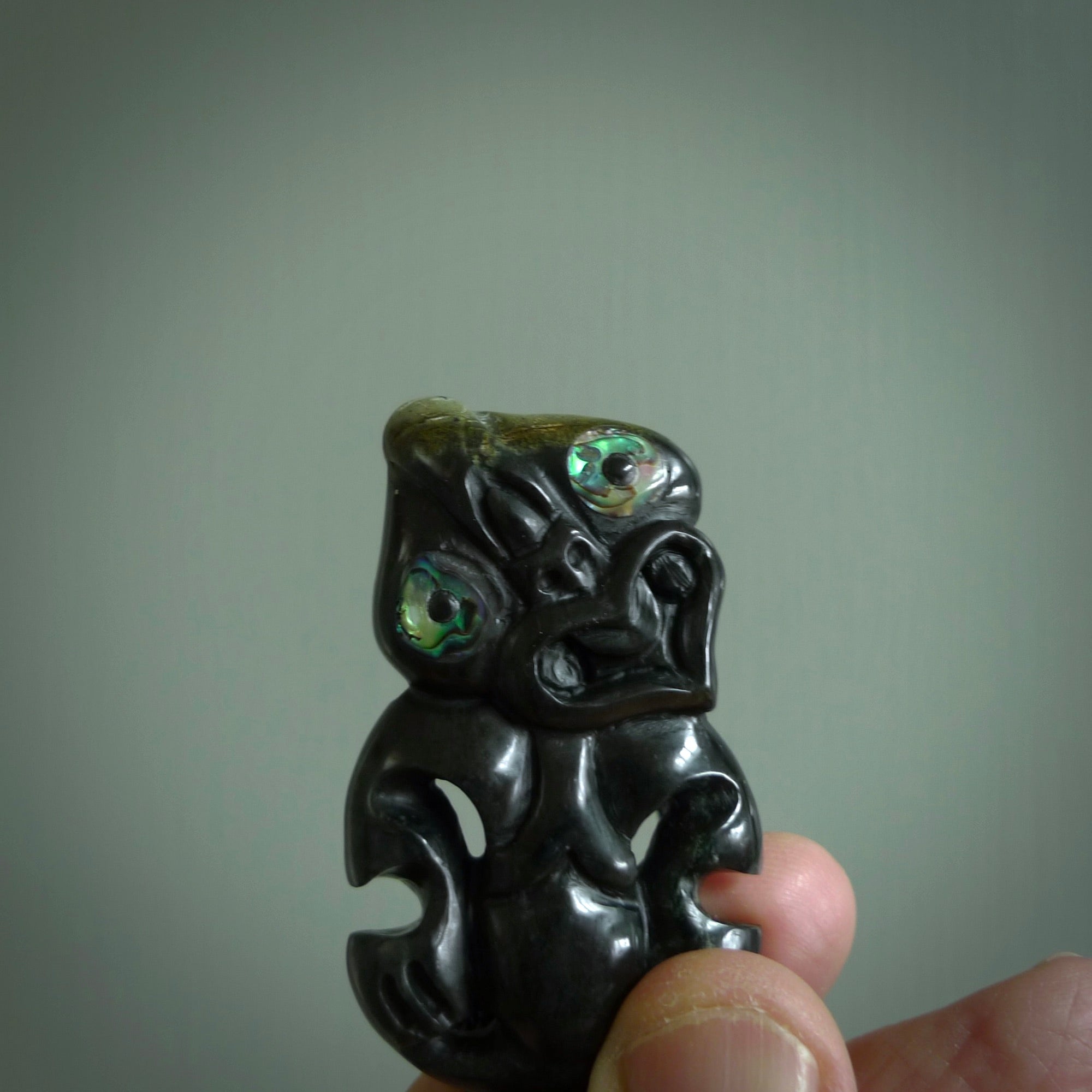 This is a medium sized tiki - carved from gorgeous Marsden jade. The craftsmanship is superb, this piece is as well carved as any we have seen. The cord is an adjustable plaited cord in black.