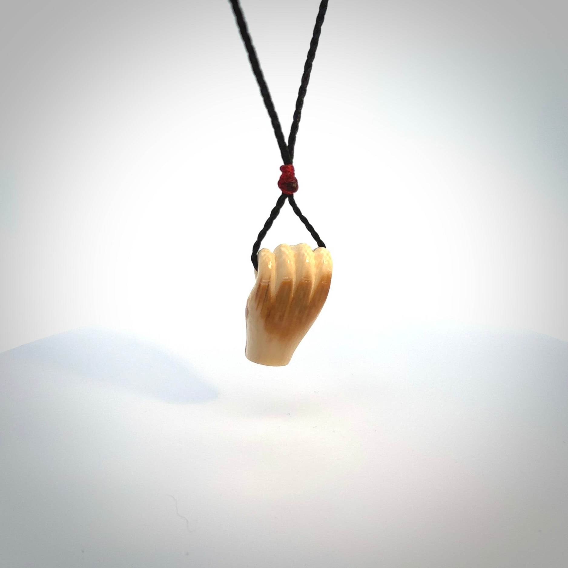 Hand carved pendant symbolising strength and hope - Shown worn. Carved by NZ Pacific from ancient woolly mammoth tusk. Unique jewellery for sale online.