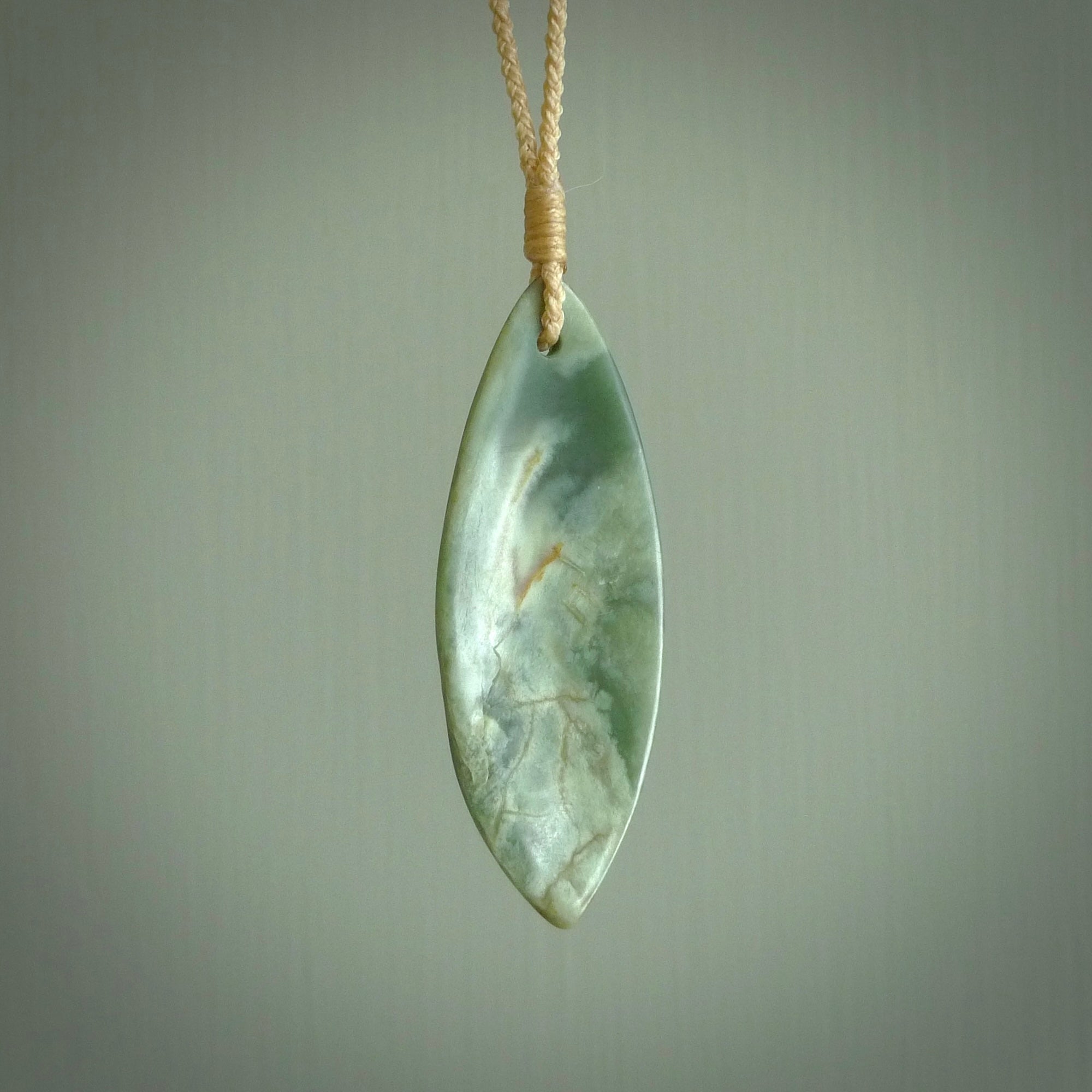 This is a lovely New Zealand Jade, pounamu drop pendant. Hand carved for us by Ric Moor. It is bound with an adjustable beige coloured cord which is length adjustable. Free worldwide shipping.