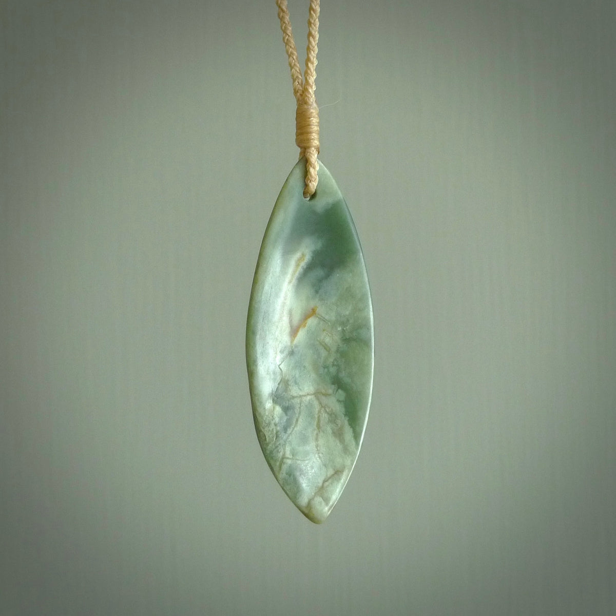 This is a lovely New Zealand Jade, pounamu drop pendant. Hand carved for us by Ric Moor. It is bound with an adjustable beige coloured cord which is length adjustable. Free worldwide shipping.