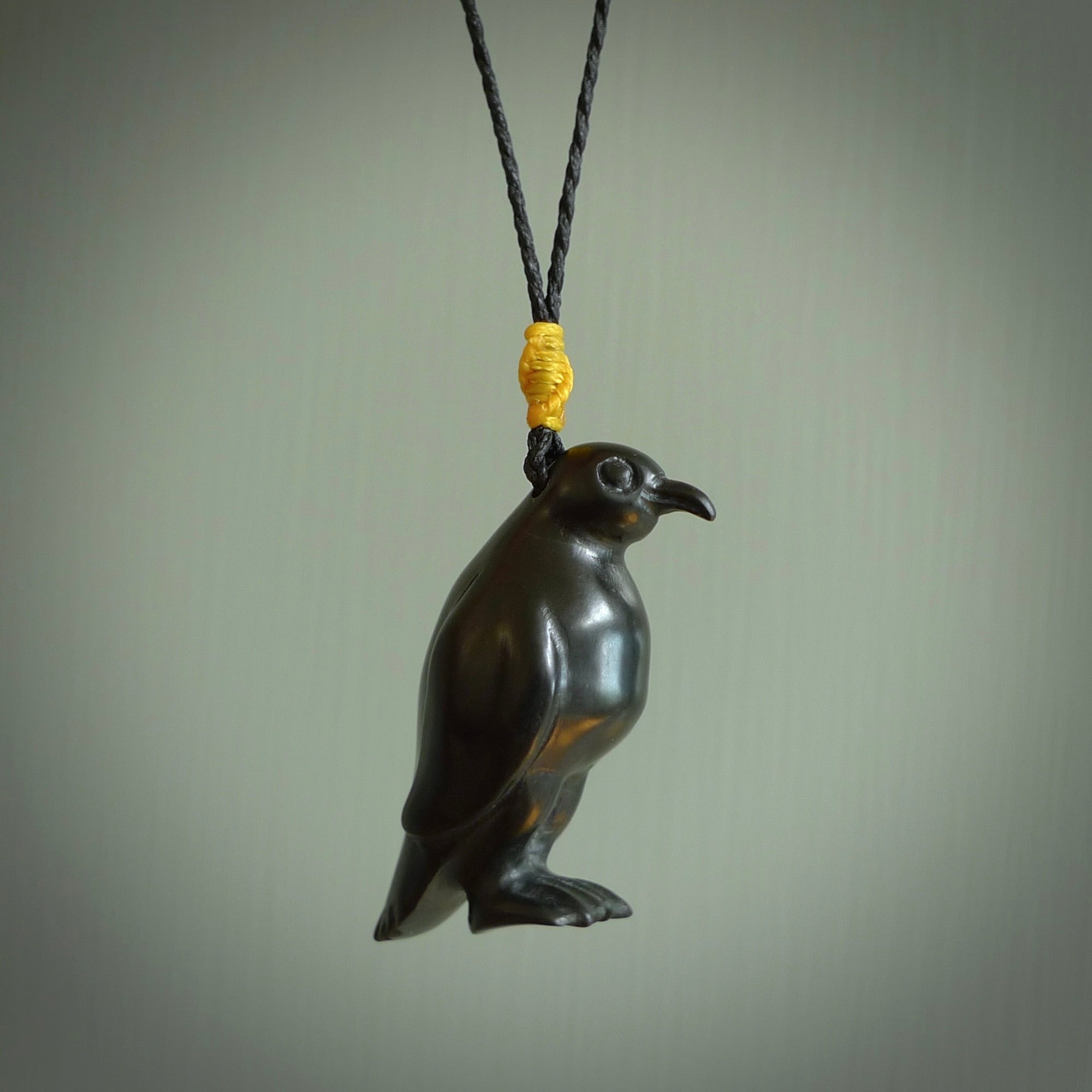 This pendant is a hand carved YELLOW EYED penguin. We've carved this from a lovely piece of black jade and we provide it with a hand plaited cord. Shipping is free worldwide.