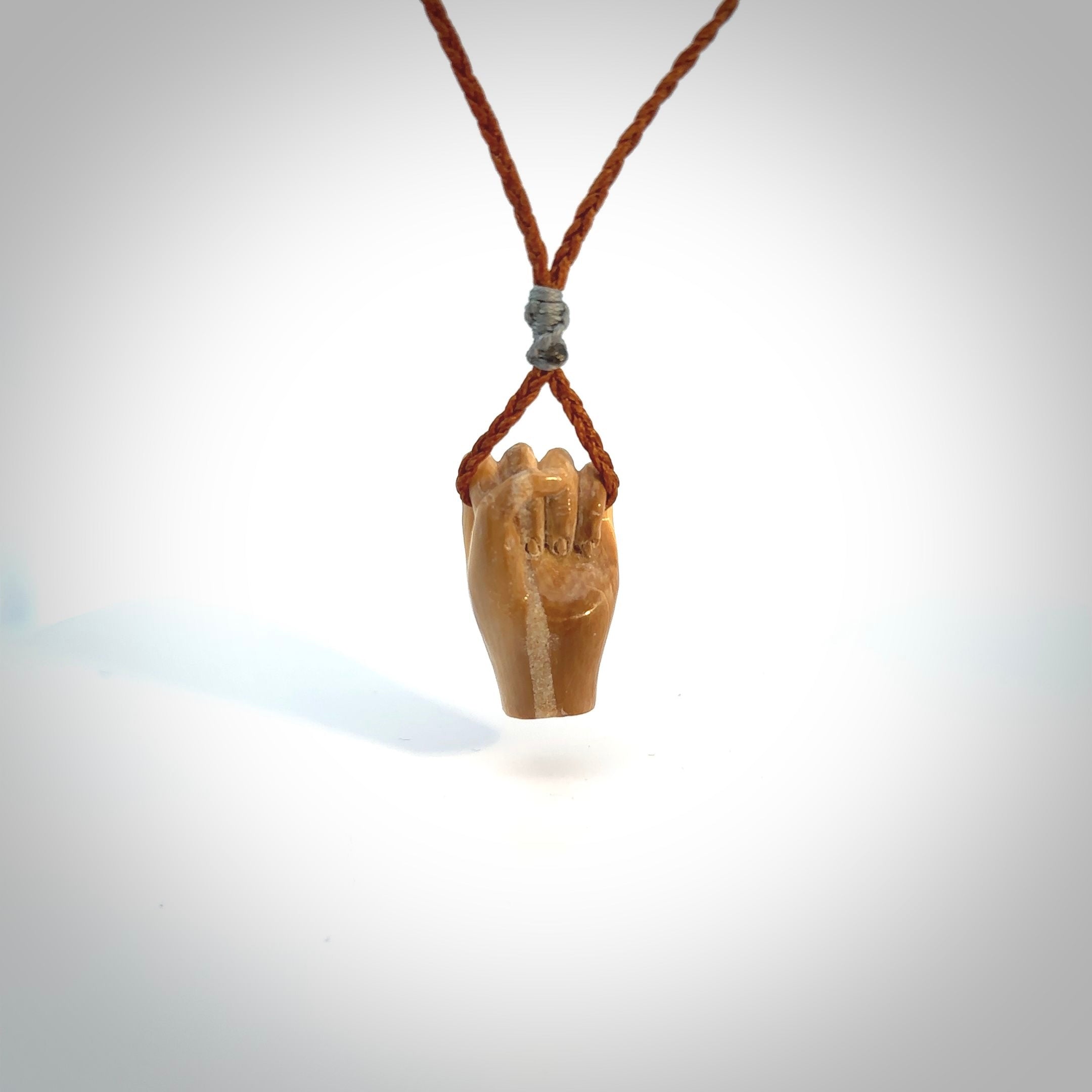 Hand carved pendant symbolising strength and hope - Shown worn. Carved by NZ Pacific from ancient woolly mammoth tusk. Unique jewellery for sale online.