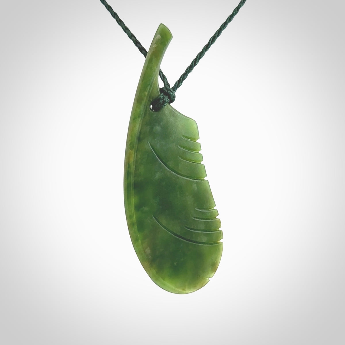 A hand carved large New Zealand Flower Jade feather necklace. The cord is a green colour and is an adjustable length. A large sized hand made Jade feather necklace by New Zealand artist Kerry Thompson. One off work of art to wear.