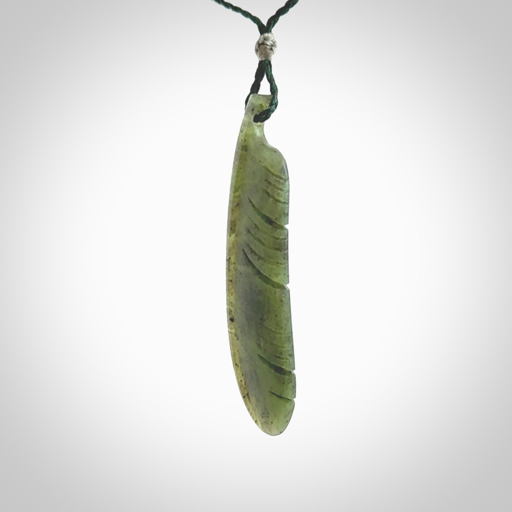 A hand carved large New Zealand Totoweka Jade feather necklace. The cord is a green colour and is an adjustable length. A large sized hand made Jade feather necklace by New Zealand artist Kerry Thompson. One off work of art to wear.