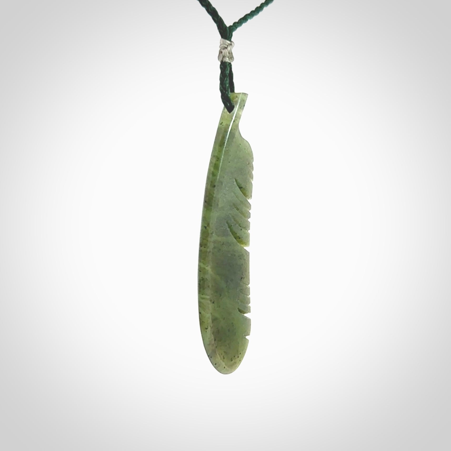 A hand carved large New Zealand Totoweka Jade feather necklace. The cord is a green colour and is an adjustable length. A large sized hand made Jade feather necklace by New Zealand artist Kerry Thompson. One off work of art to wear.