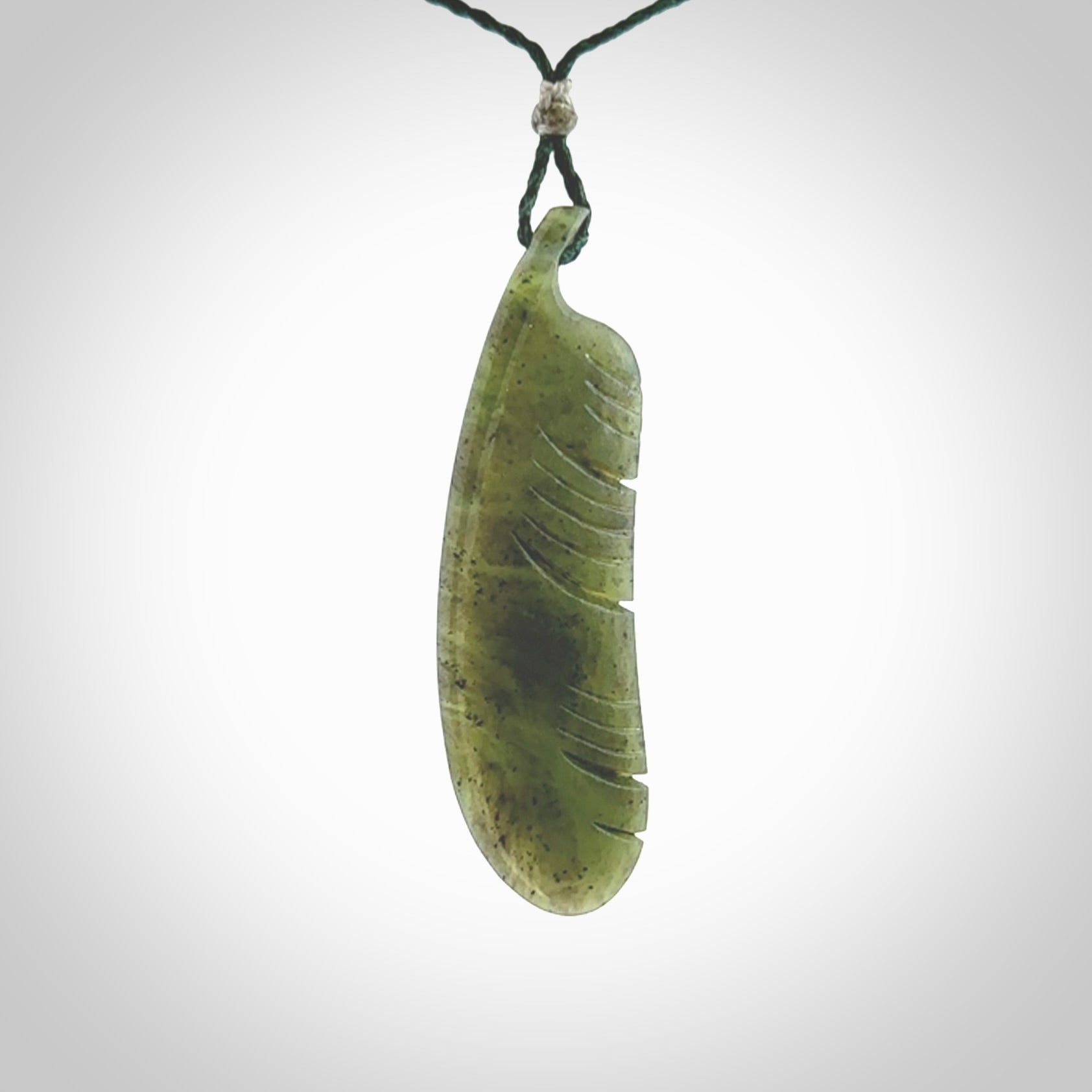 A hand carved large New Zealand Totoweka Jade feather necklace. The cord is a green colour and is an adjustable length. A large sized hand made Jade feather necklace by New Zealand artist Kerry Thompson. One off work of art to wear.