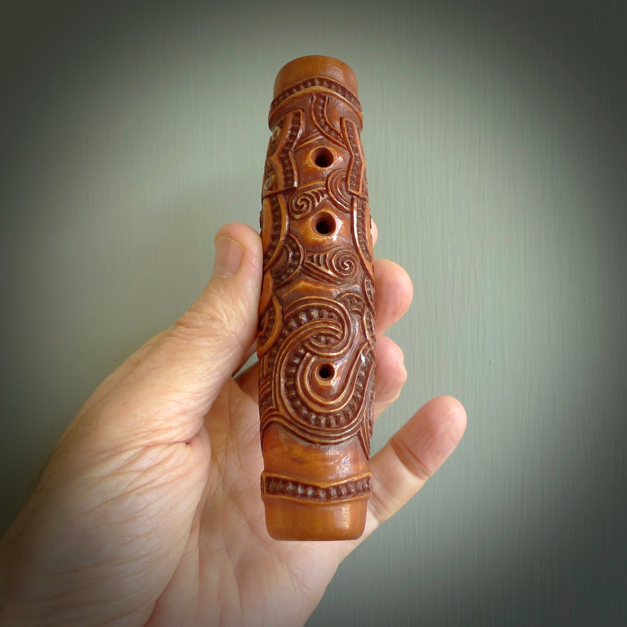 A traditional hand carved Māori Kōauau flute. This piece is made from bone and is a fully functioning musical instrument and can be played. Beautiful ethnic art hand made by NZ Pacific. One only traditional flute by Yuri Terenyi.