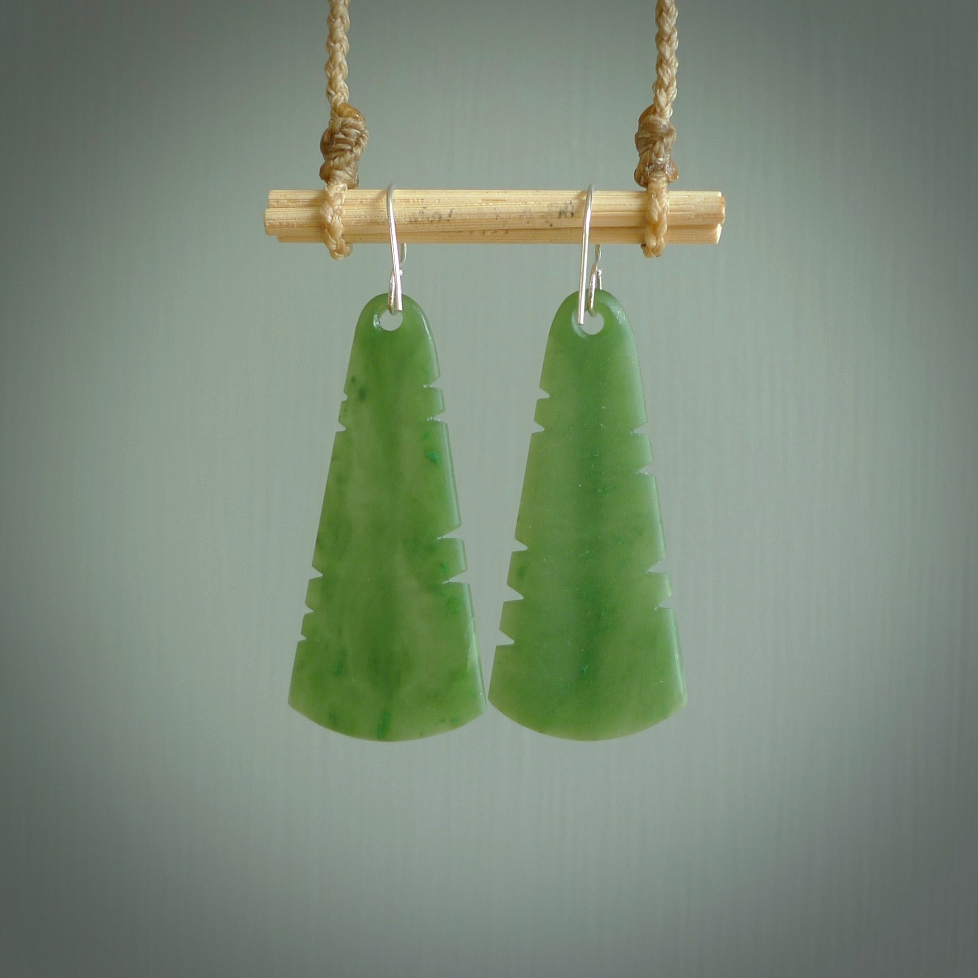 This picture shows New Zealand Pounamu, jade feather earrings with sterling silver hooks. Hand made unique and contemporary feather earrings by Kerry Thompson. Hand carved here in New Zealand from New Zealand Jade. One pair only.