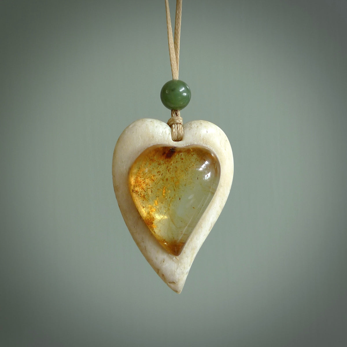 This is a hand carved whalebone heart with amber pendant. It is made from whale bone. This is a medium sized necklace and is a very unique, one only, pendant that is a collectors piece. Hand carved by New Zealand artist, Sami.