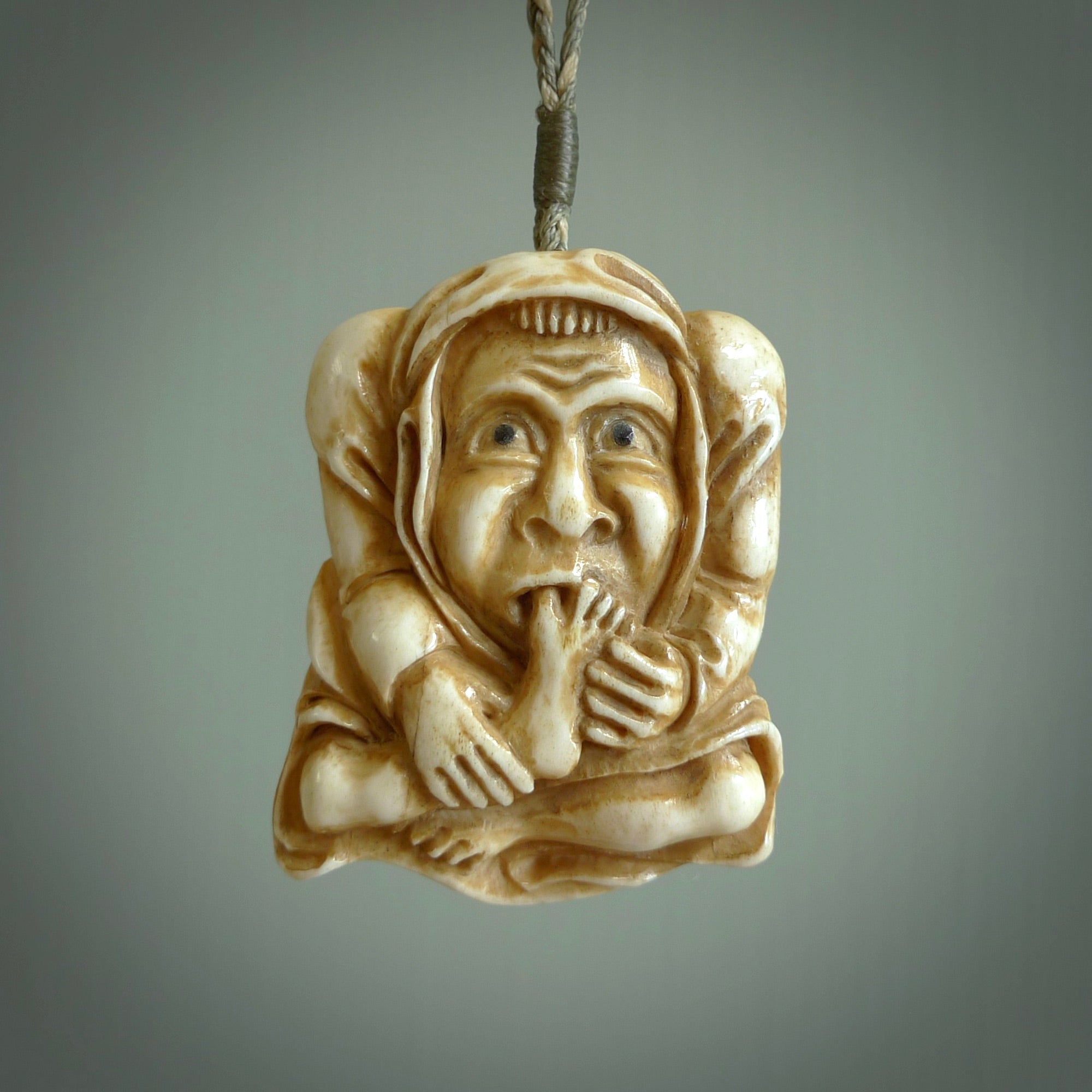 Hand carved incredible stained bone gargoyle face carving. A stunning work of art. This pendant was hand carved in bone with buffalo horn inlay for the eyes by Yuri Terenyi. A one off collectors item that has been hand crafted to be worn or displayed.