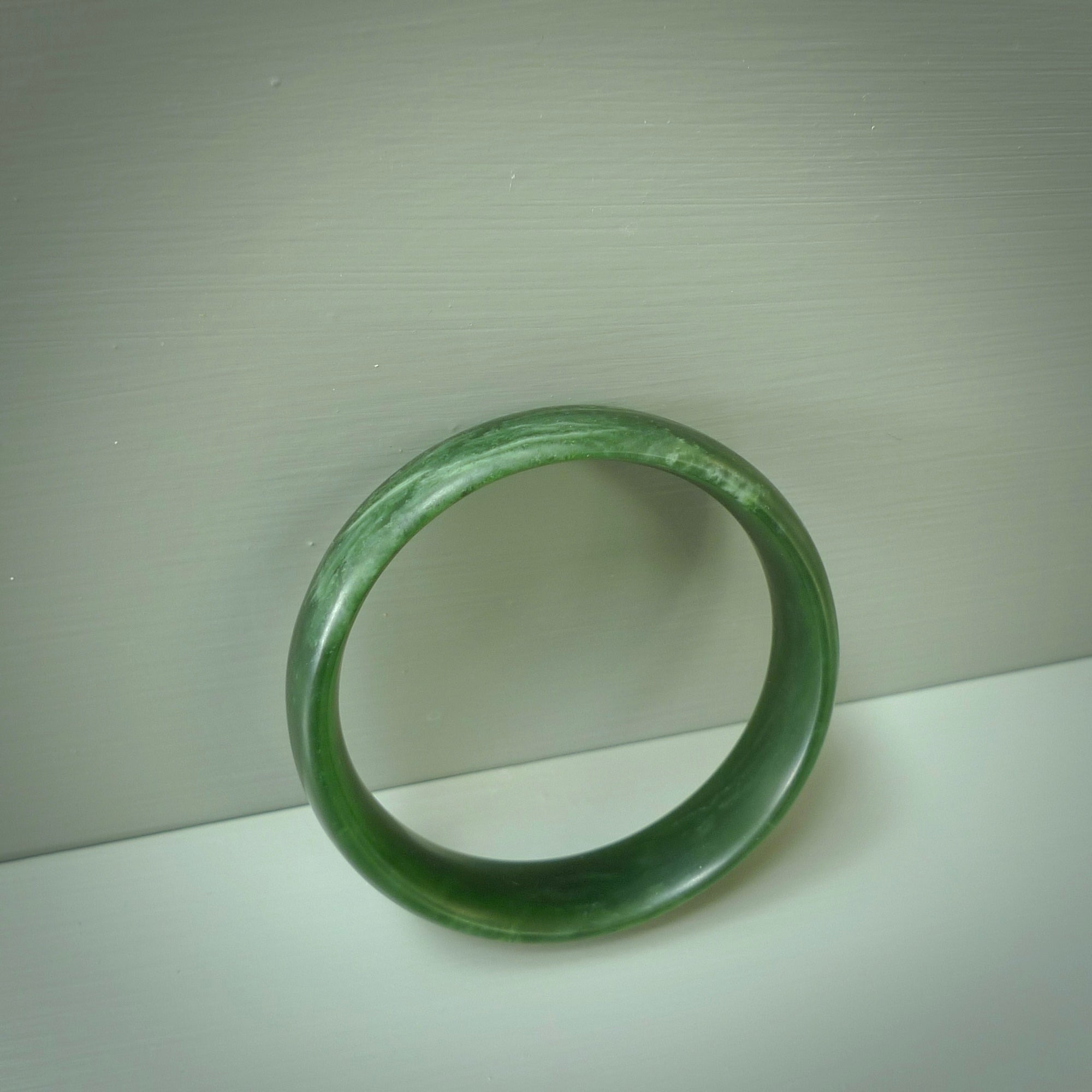 Hand carved New Zealand Jade bangle with matte finish, by Ric Moor. This is a spectacular one off, bracelet hand made in New Zealand from gorgeous Jade. Unique art to wear, delivered in a woven kete pouch. Real New Zealand Jade. Outstanding craftsmanship by New Zealand Master Carver Ric Moor.