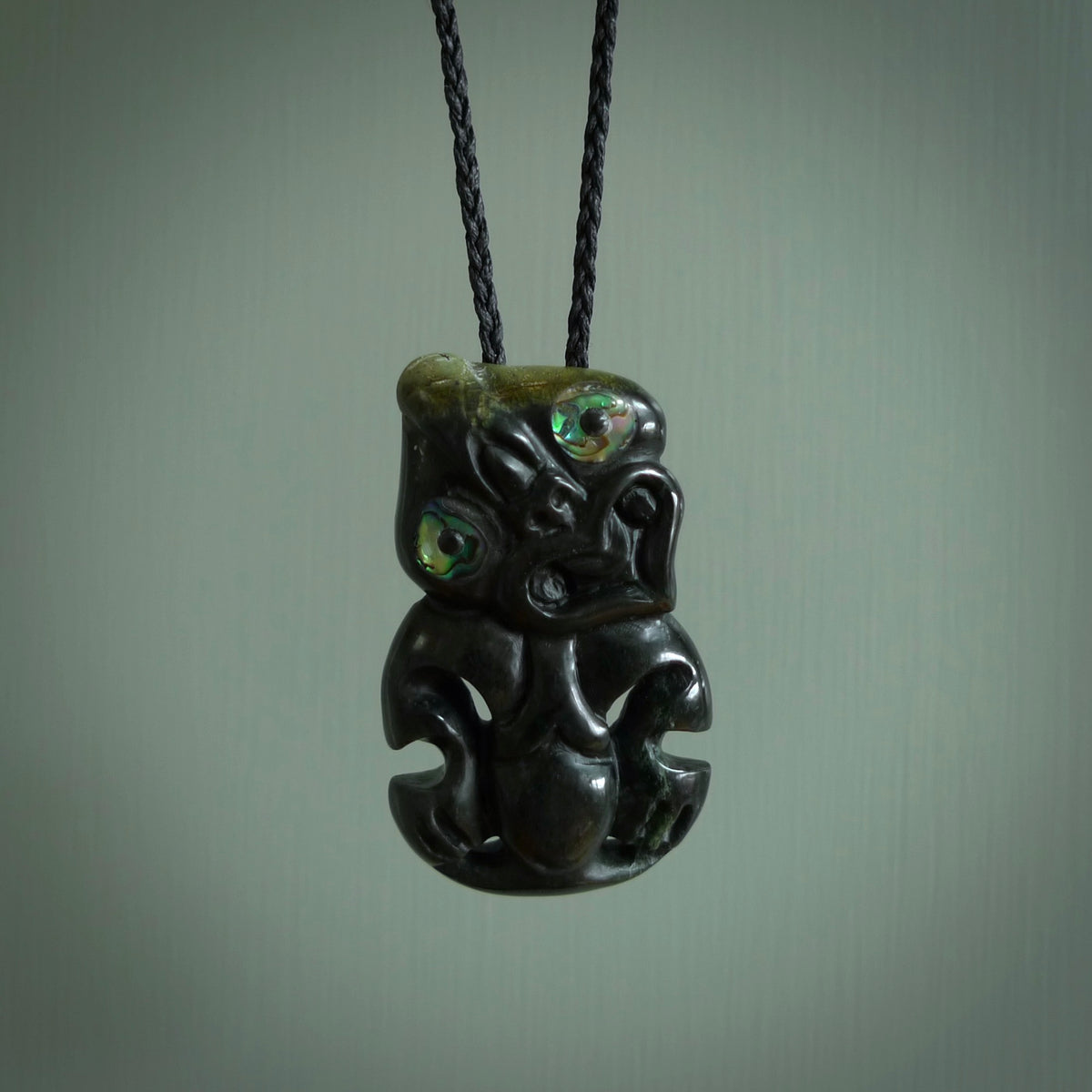 This is a medium sized tiki - carved from gorgeous Marsden jade. The craftsmanship is superb, this piece is as well carved as any we have seen. The cord is an adjustable plaited cord in black.