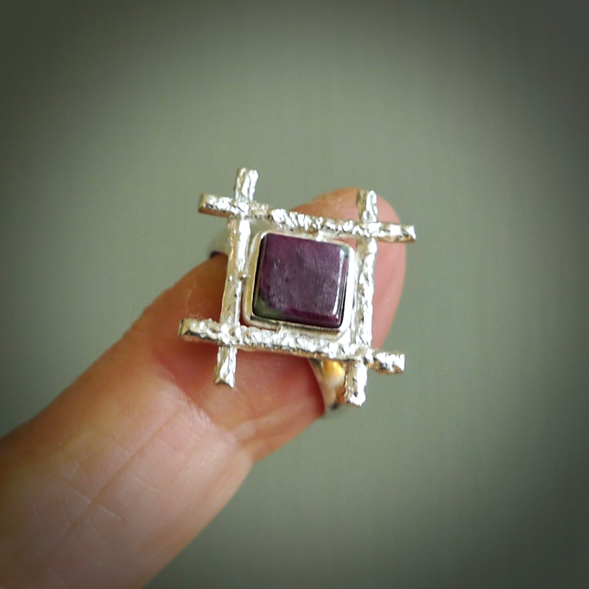 This is a handcrafted New Zealand Ruby, stone with sterling silver ring. This is a solid little work of art. We ship this worldwide for free and are happy to answer any questions that you may have about these or other products on our website. Hand made by Ana Krakosky and delivered in a woven kete pouch.