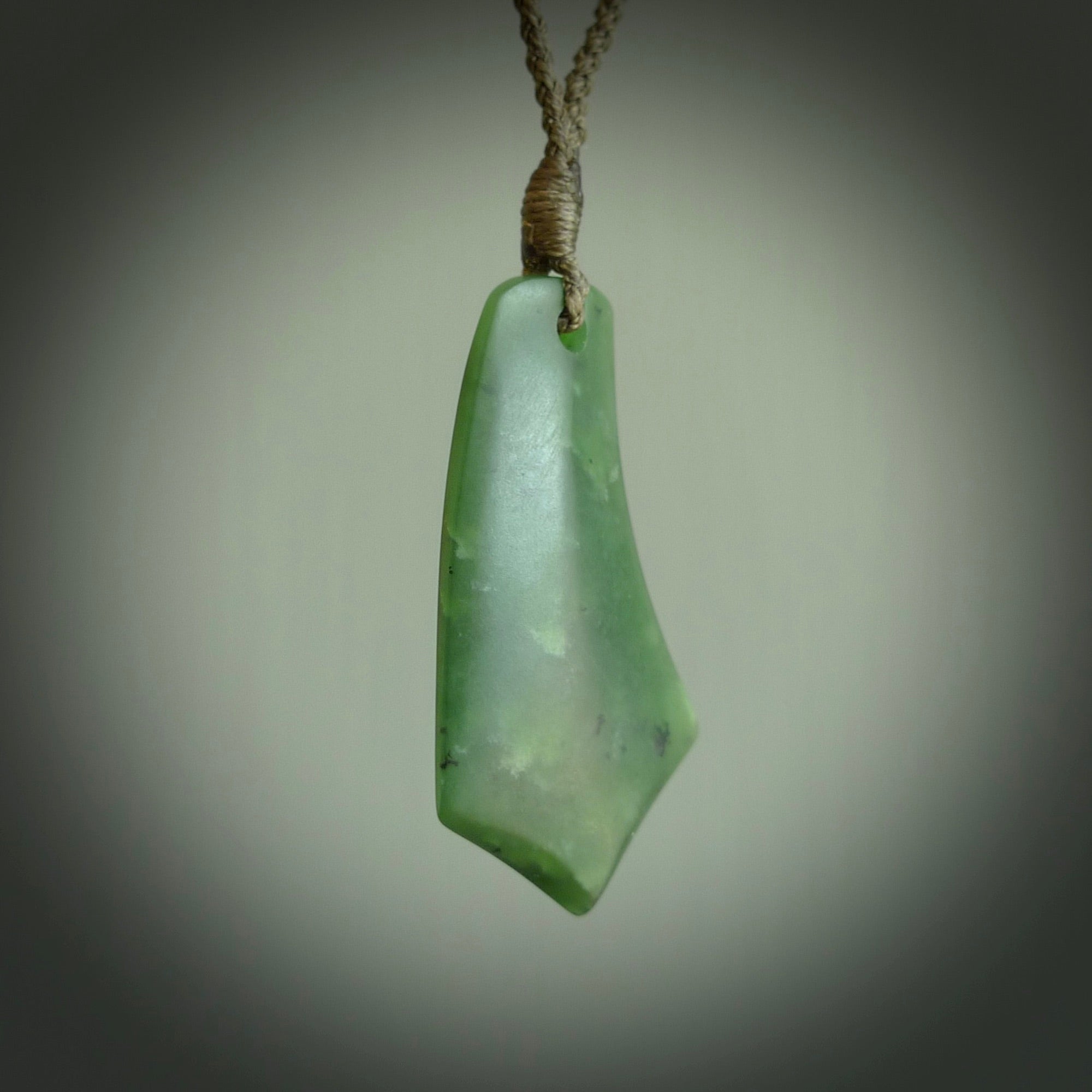 This picture shows a medium sized hand carved jade drop pendant by Ric Moor. The jade is a wonderful deep green. It is suspended from a khaki adjustable cord. Delivery is free worldwide.