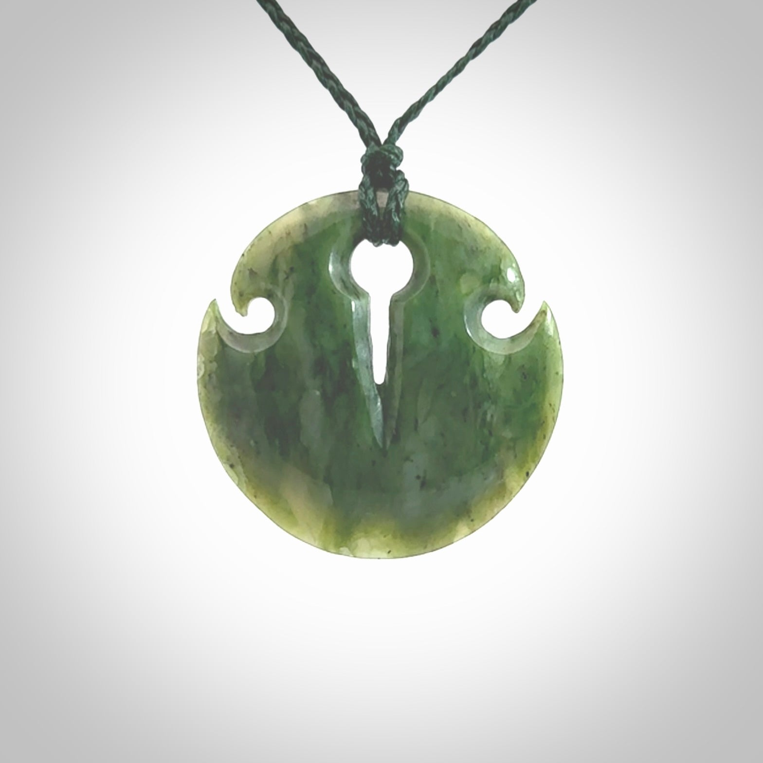 Green jade contemporary shield drop pendant hand carved for you by NZ Pacific. Hand carved jewellery made from jade and for sale online. One only pendant with adjustable green cord.