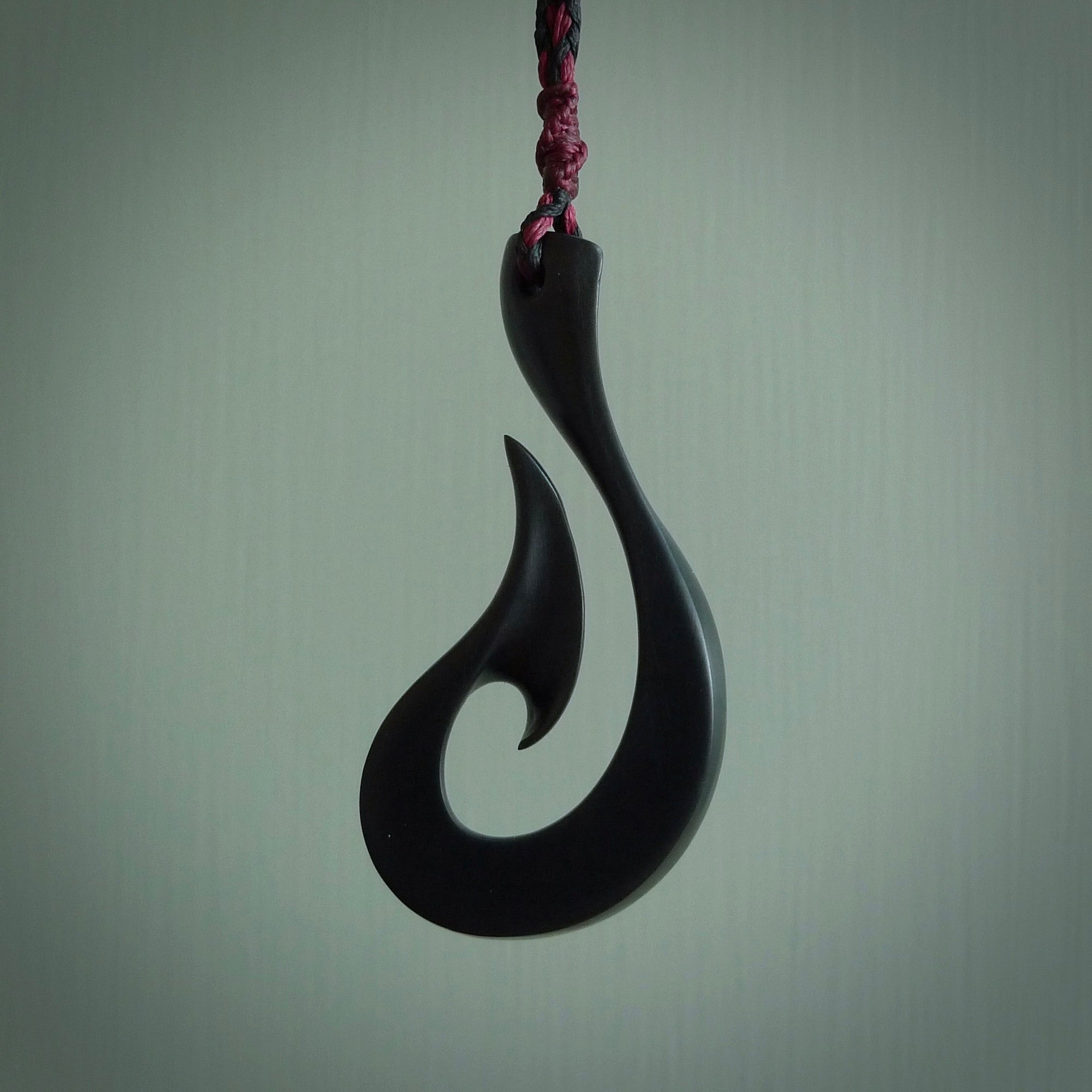 A hand carved large Black Jade Hook, Matau, necklace. The cord is a black colour and is a fixed length. A large sized hand made hook necklace by New Zealand artist Kerry Thompson. One off work of art to wear.