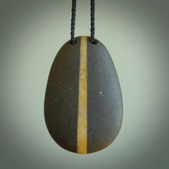 Argillite drop pendant with Golden Quartzite heart. Hand carved by Rhys Hall for NZ Pacific. Handmade jewellery for sale online. The cord is a 3-braid plait in black and has a loop and pebble toggle closure. Large drop necklace for men and women. Unique Golden Quartzite drop necklace hand made from Argillite and Golden Quartzite.