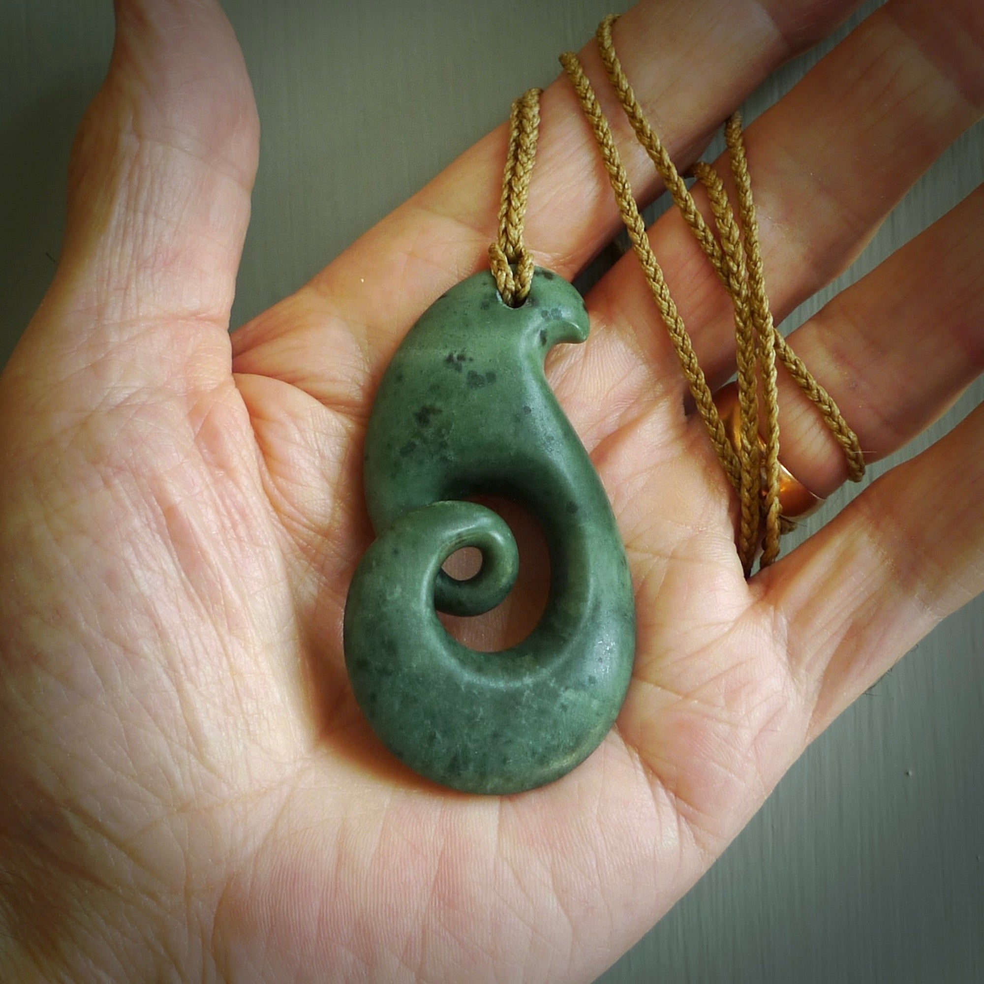 A hand carved koru pendant from New Zealand Jade. The cord is a tan colour and is adjustable. A large hand made Koru necklace by New Zealand artist Kerry Thompson.