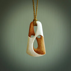 A hand carved bone contemporary, intricate, twist pendant. The cord is a tan colour and is adjustable. A medium sized hand made contemporary necklace by New Zealand artist Tonijae Brockway. Tonijae has stained parts of the bone which really add to the dimension of this pendant. One off work of art to wear.