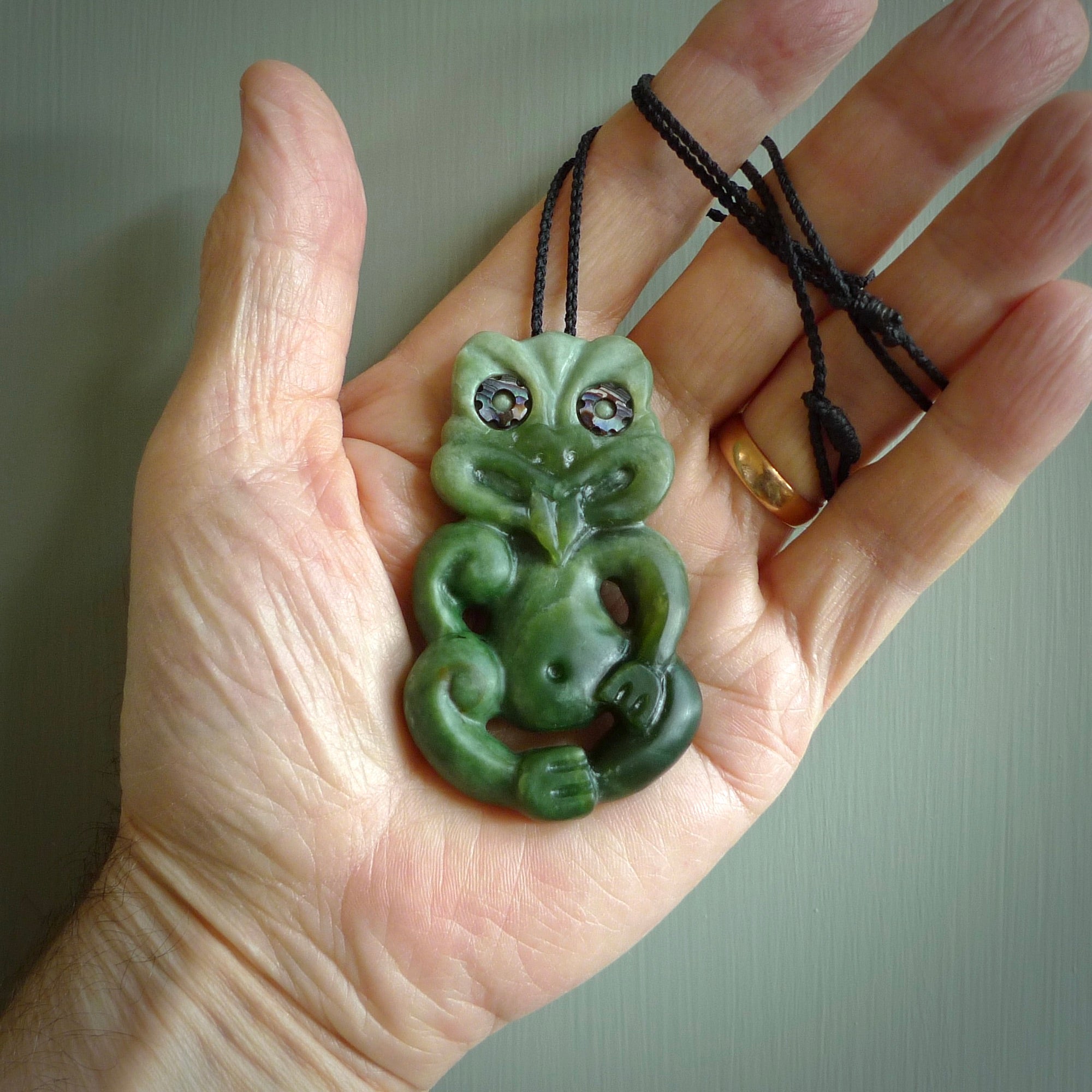 This is a large sized tiki - carved from gorgeous Marsden jade. The craftsmanship is superb, this piece is as well carved as any we have seen. The cord is an adjustable four plaited cord in black. One only by Ana Krakosky.