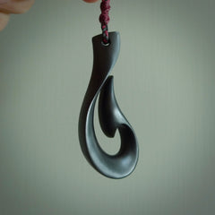 A hand carved large Black Jade Hook, Matau, necklace. The cord is a black colour and is a fixed length. A large sized hand made hook necklace by New Zealand artist Kerry Thompson. One off work of art to wear.