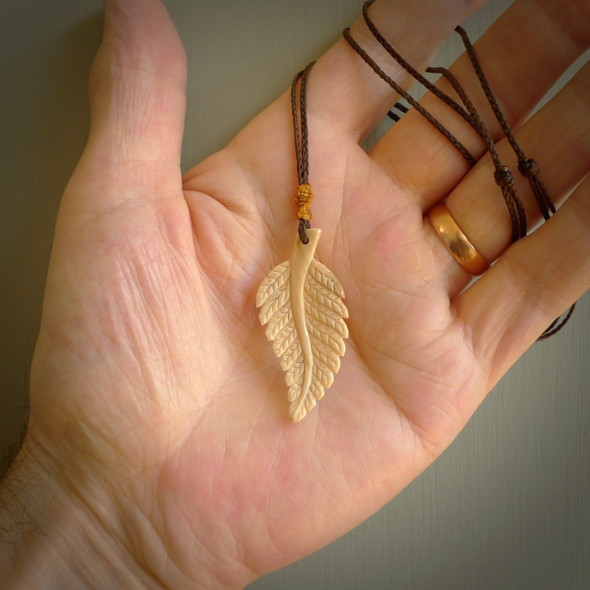 Hand carved woolly mammoth tusk fern pendant. Made in New Zealand. Unique hand made gifts from NZ Pacific. Hand carved fern necklace from ancient woolly mammoth tusk.