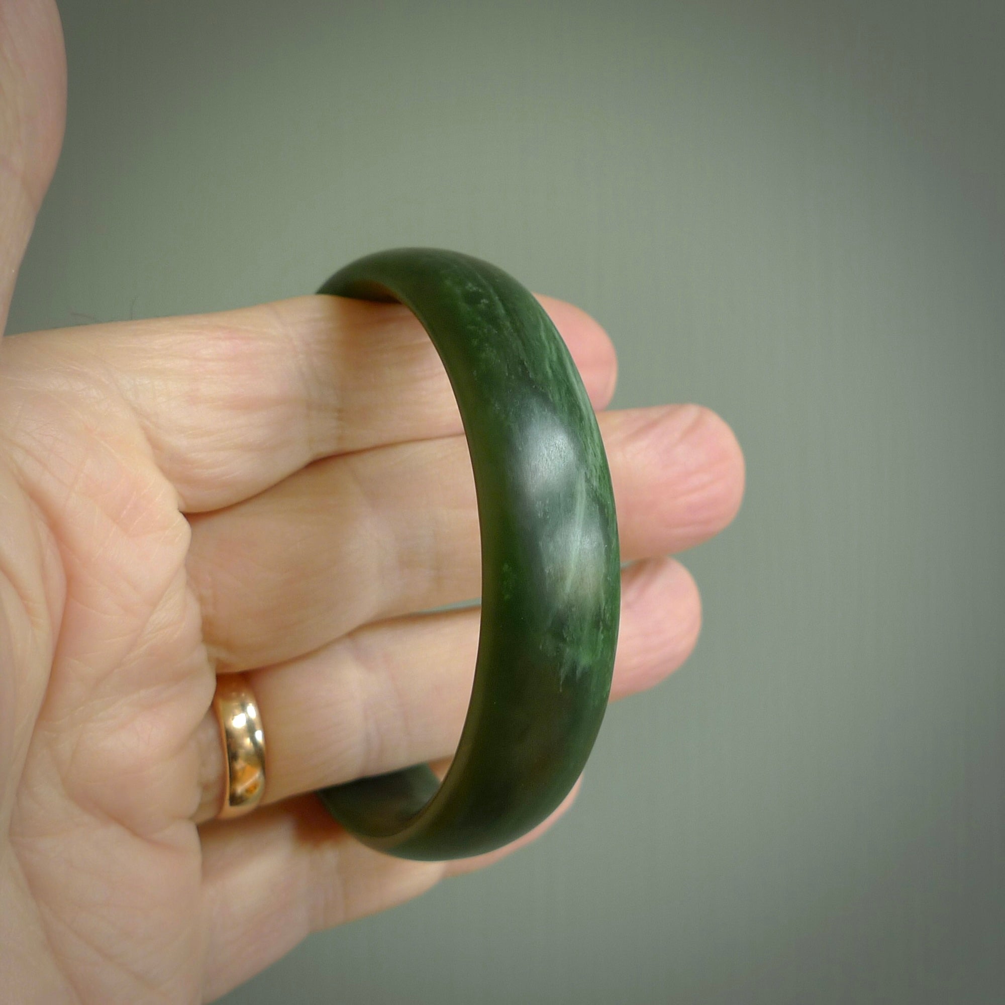 Hand carved New Zealand Jade bangle with matte finish, by Ric Moor. This is a spectacular one off, bracelet hand made in New Zealand from gorgeous Jade. Unique art to wear, delivered in a woven kete pouch. Real New Zealand Jade. Outstanding craftsmanship by New Zealand Master Carver Ric Moor.