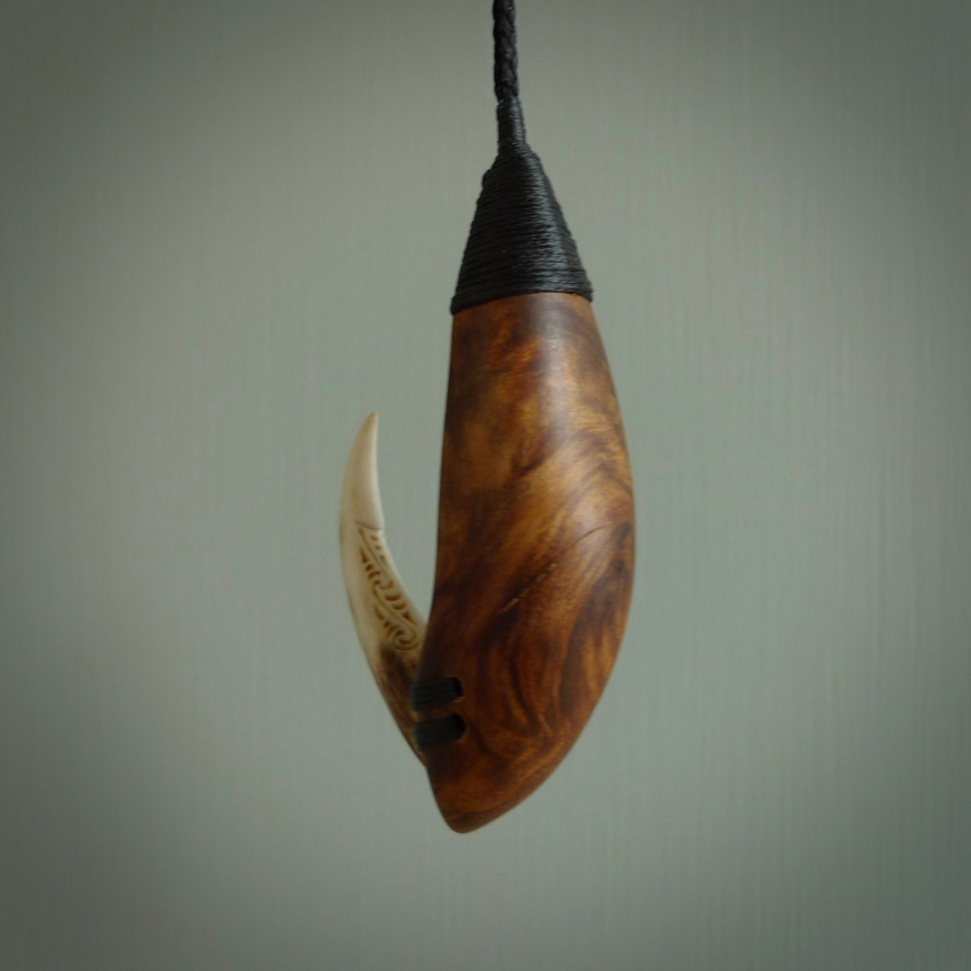 This picture shows a large matau, hook called a pā kahawai. It is carved from deer antler bone, wood, and paua shell. One only, free shipping worldwide. Provided with an adjustable black cord. Stunning work of Art to Wear by Fumio Noguchi.