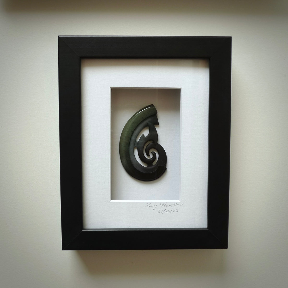 A hand carved large New Zealand Jade koru necklace that has been framed and signed by artist Kerry Thompson. A large sized hand made koru necklace by New Zealand artist Kerry Thompson. One off framed work of art to wear. Delivered with Express Courier.