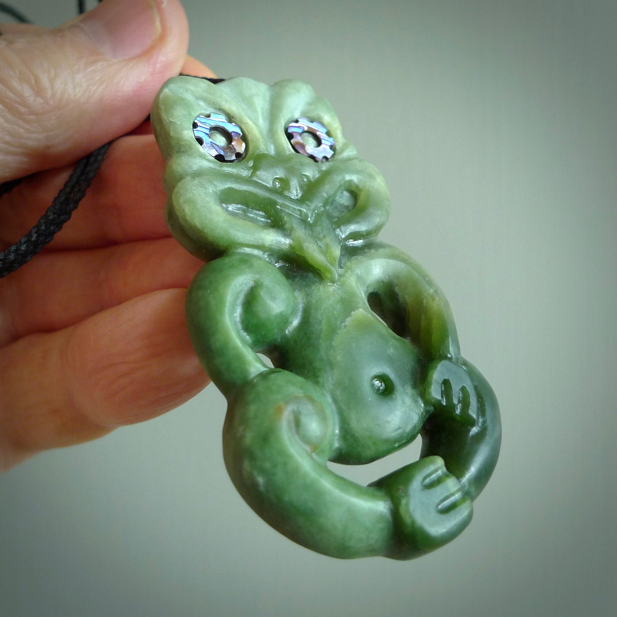 This is a large sized tiki - carved from gorgeous Marsden jade. The craftsmanship is superb, this piece is as well carved as any we have seen. The cord is an adjustable four plaited cord in black. One only by Ana Krakosky.