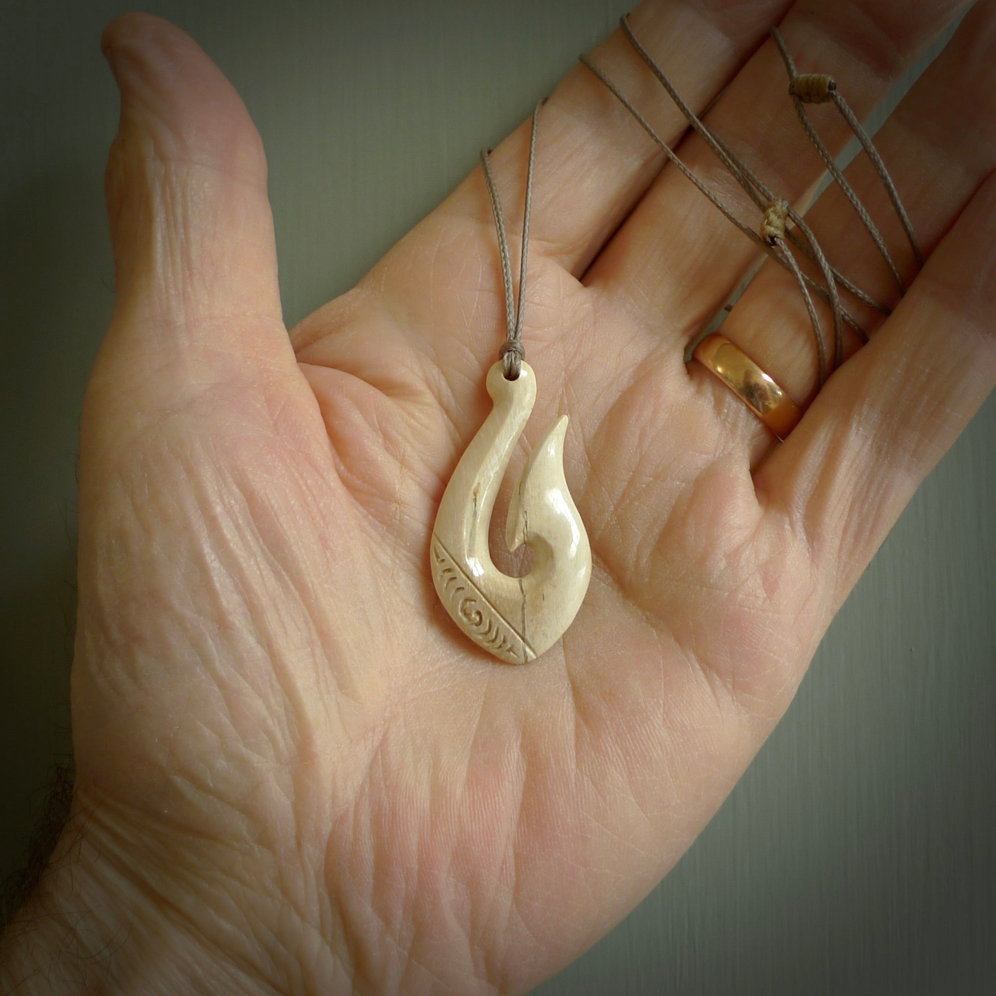 A fish hook necklace (hei-matau) hand-carved in a traditional style from Woolly Mammoth Tusk. Delivered on an adjustable cord in one of our kete pouches.