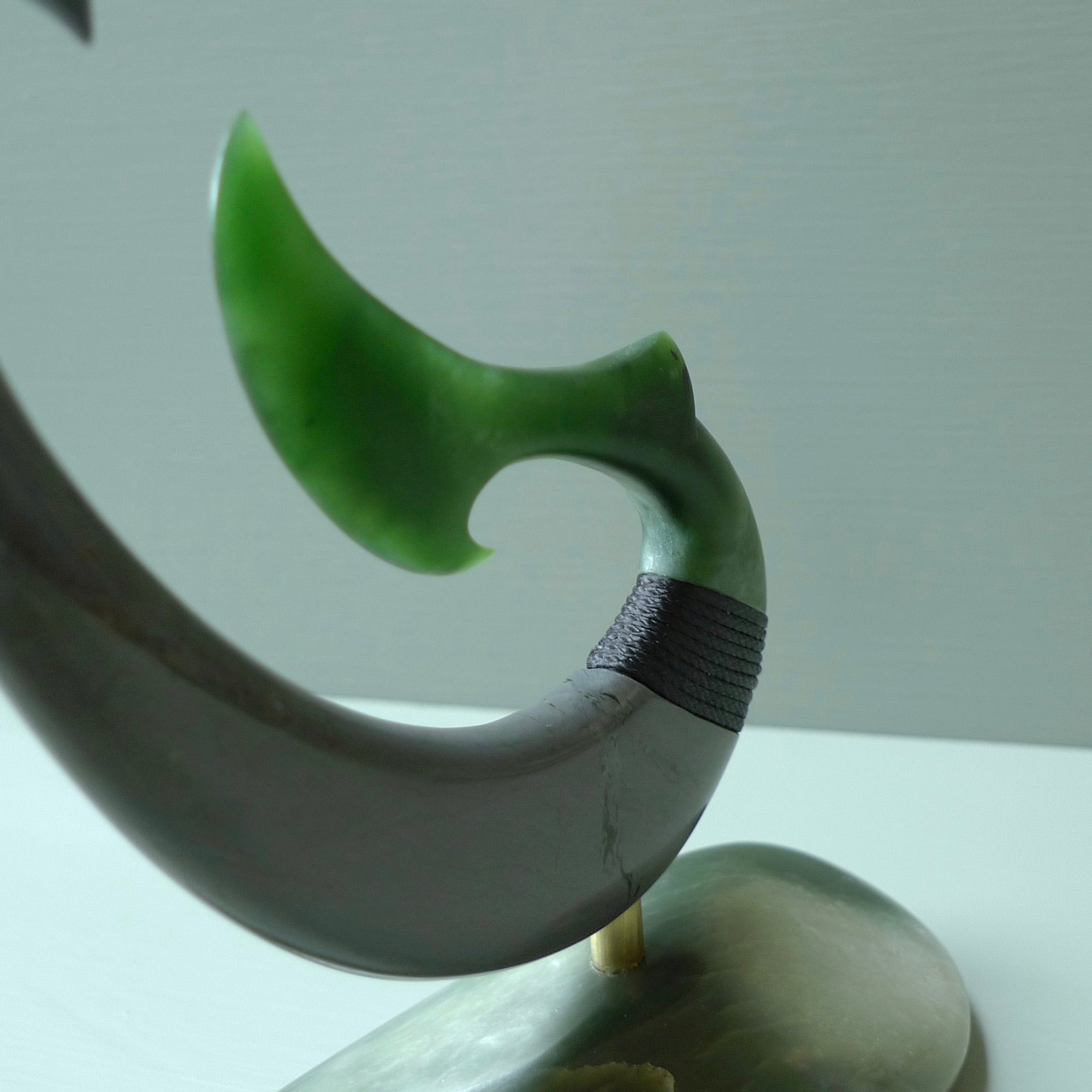 Hand carved large New Zealand Jade and Argillite Matau, hook carving displayed in a New Zealand Inanga Pounamu stand sculpture. Hand carved here in New Zealand by Kerry Thompson. This is a 'one only' sculpture, a beautiful display piece.