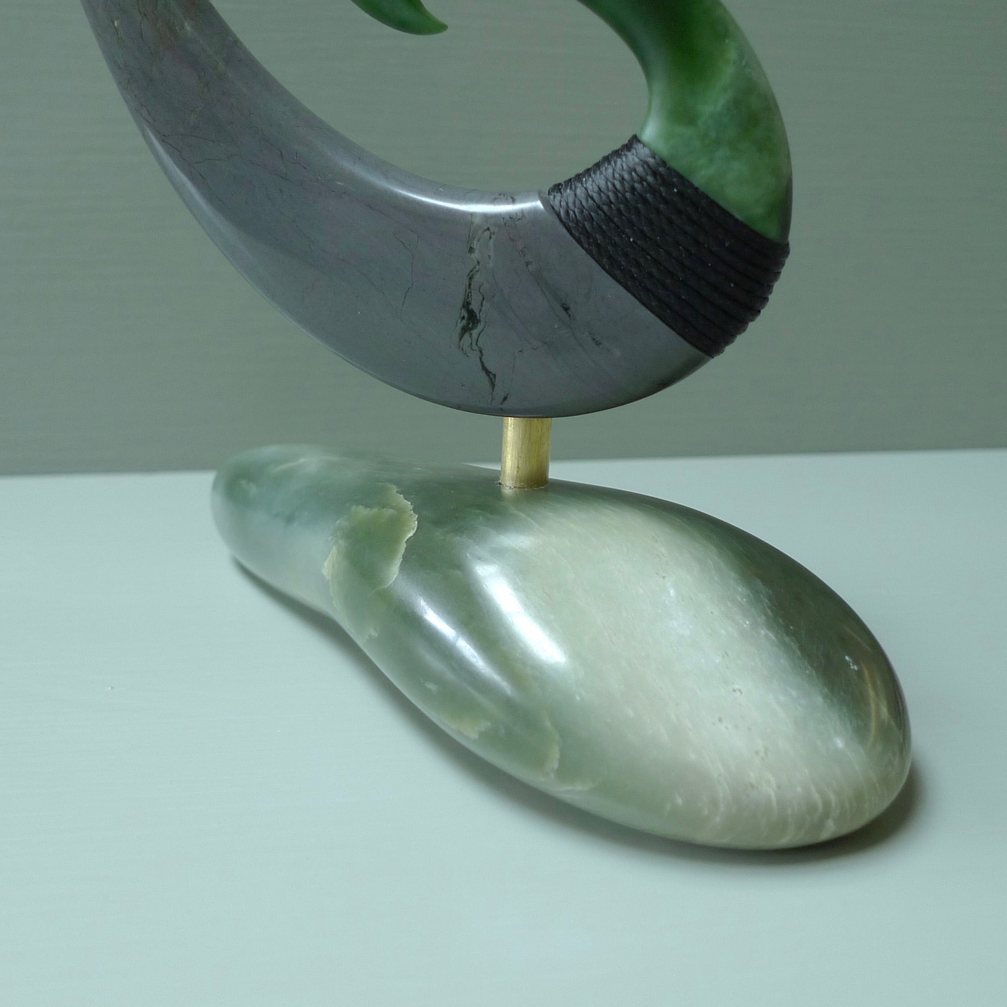 Hand carved large New Zealand Jade and Argillite Matau, hook carving displayed in a New Zealand Inanga Pounamu stand sculpture. Hand carved here in New Zealand by Kerry Thompson. This is a 'one only' sculpture, a beautiful display piece.