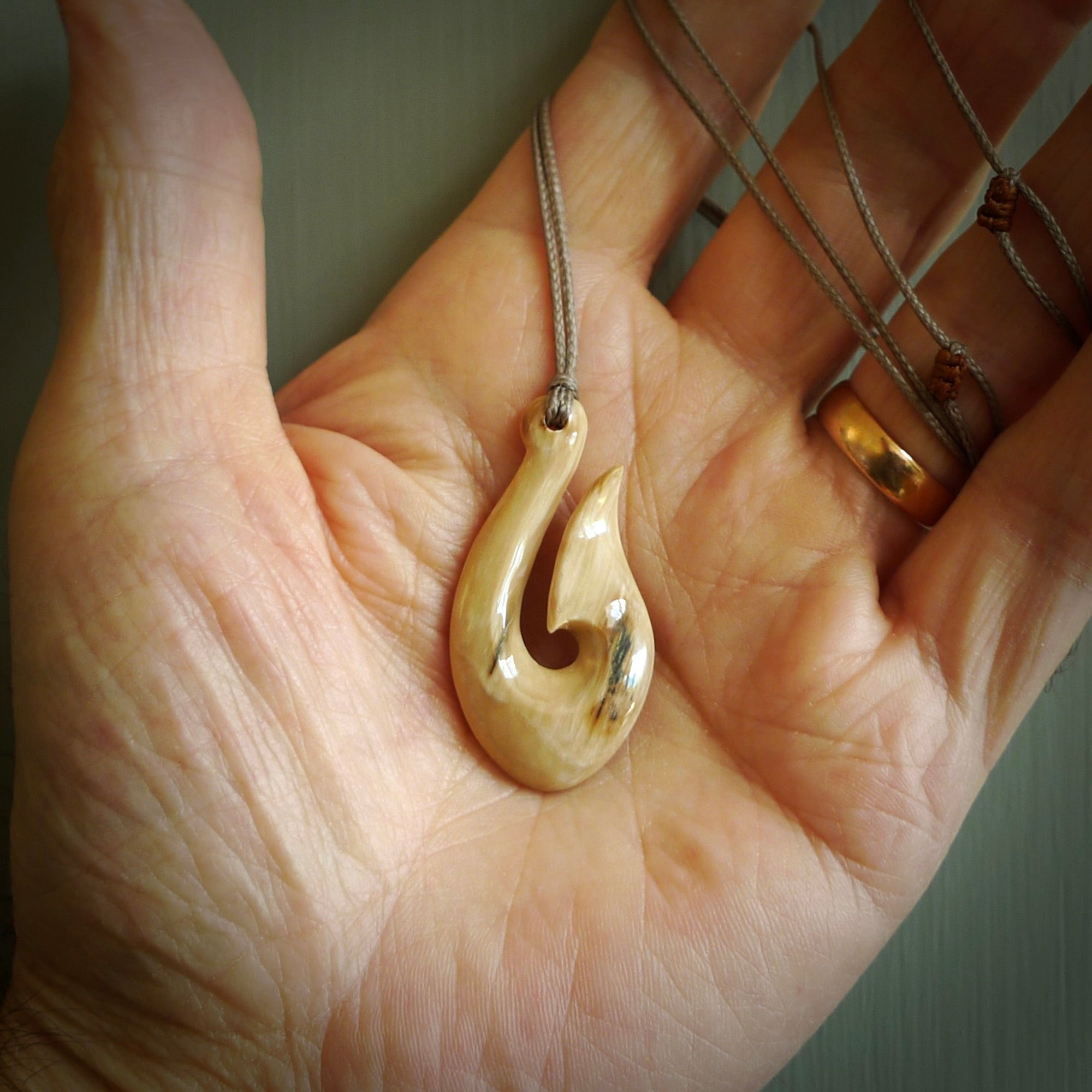 A fish hook necklace (hei-matau) hand-carved in a traditional style from Woolly Mammoth Tusk. These are glorious pieces of art to wear. Provided with adjustable cords and packaged in a woven kete pouch. Delivered with express courier.