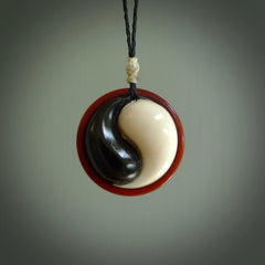 A hand carved and intricate yin and yang pendant made for us by Yuri Terenyi. This is a beautiful little piece and is emblematic of the well known and loved YIN & YANG design. It is carved from bone and buffalo horn. We have two available - one is suspended from an Ice White cord with a black floret and the other is suspended from an Black cord with Ice white floret. The necklace is adjustable.