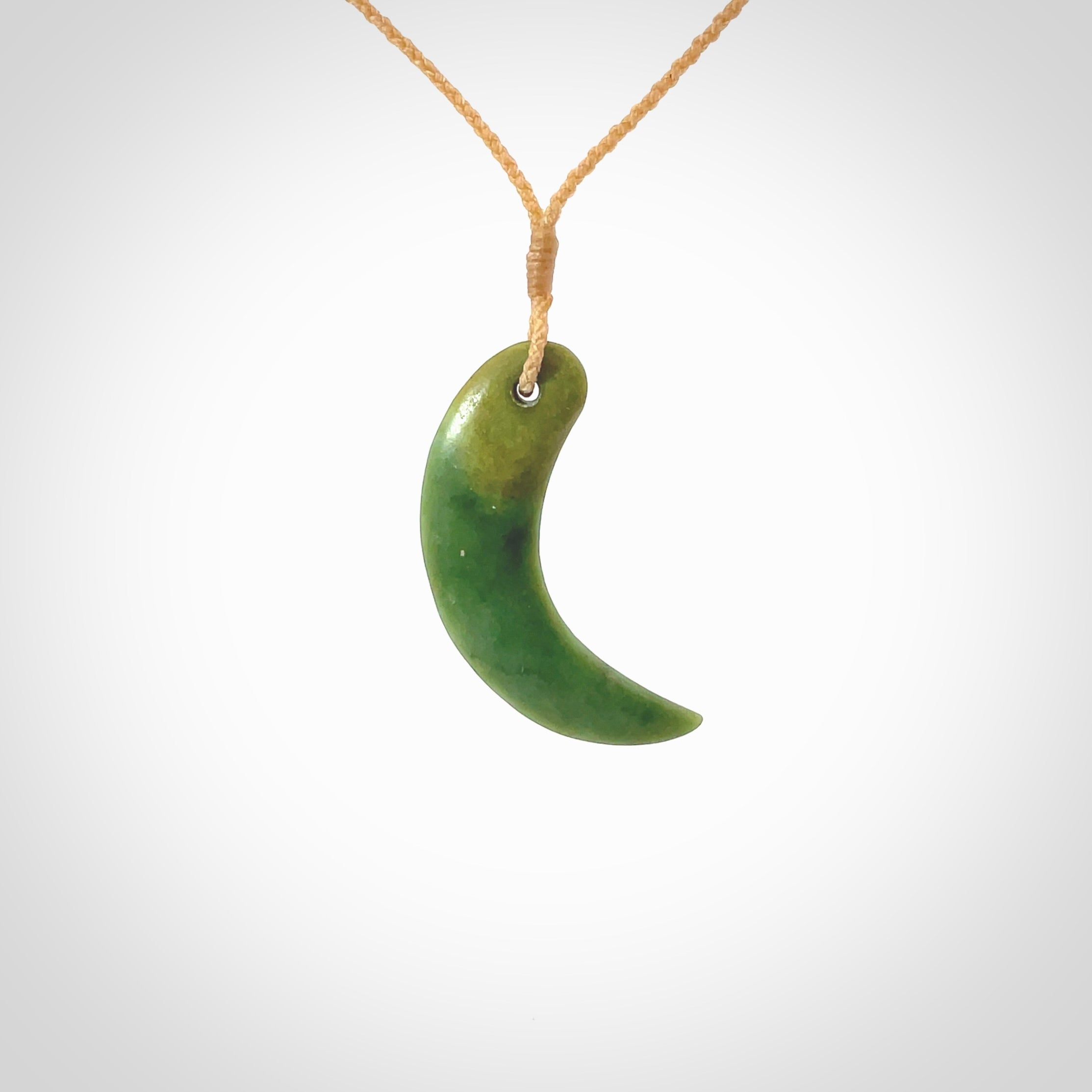 Hand carved pounamu drop pendant. Jade necklace hand made in New Zealand. A contemporary drop pendant carved from rare New Zealand flower jade. NZ Pacific jade jewellery for sale online. Provided with adjustable beige cord and packaged in a woven kete pouch.