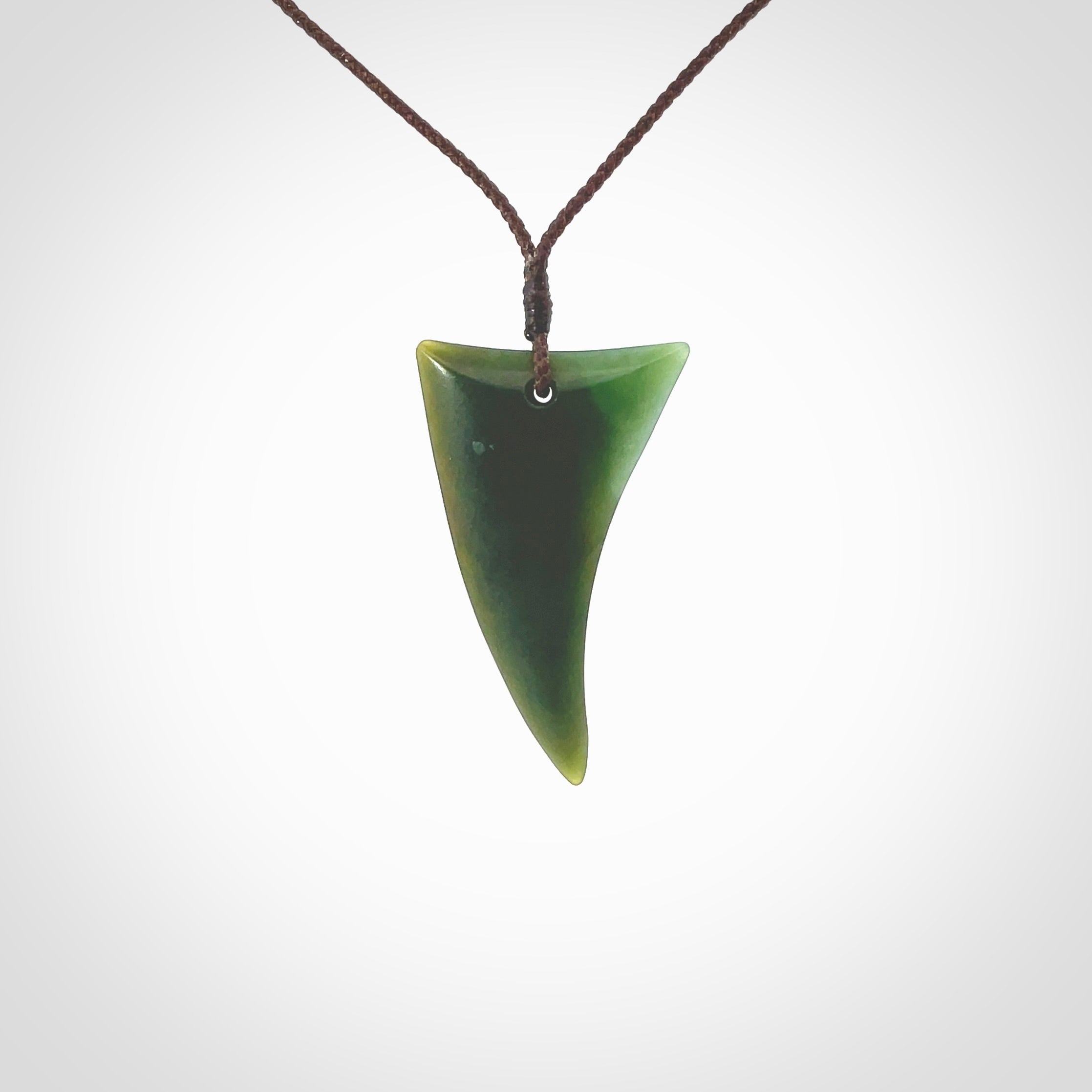 This is a lovely New Zealand Jade, pounamu drop pendant. Hand carved for us by Ric Moor. It is bound with an adjustable brown coloured cord which is length adjustable. Free worldwide shipping.