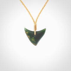 This is a lovely New Zealand Jade, pounamu drop pendant. Hand carved for us by Ric Moor. It is bound with an adjustable beige coloured cord which is length adjustable. Free worldwide shipping. The light reveals the internal structure and colour of the stone beautifully.