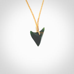 This is a lovely New Zealand Jade, pounamu drop pendant. Hand carved for us by Ric Moor. It is bound with an adjustable beige coloured cord which is length adjustable. Free worldwide shipping. The light reveals the internal structure and colour of the stone beautifully.