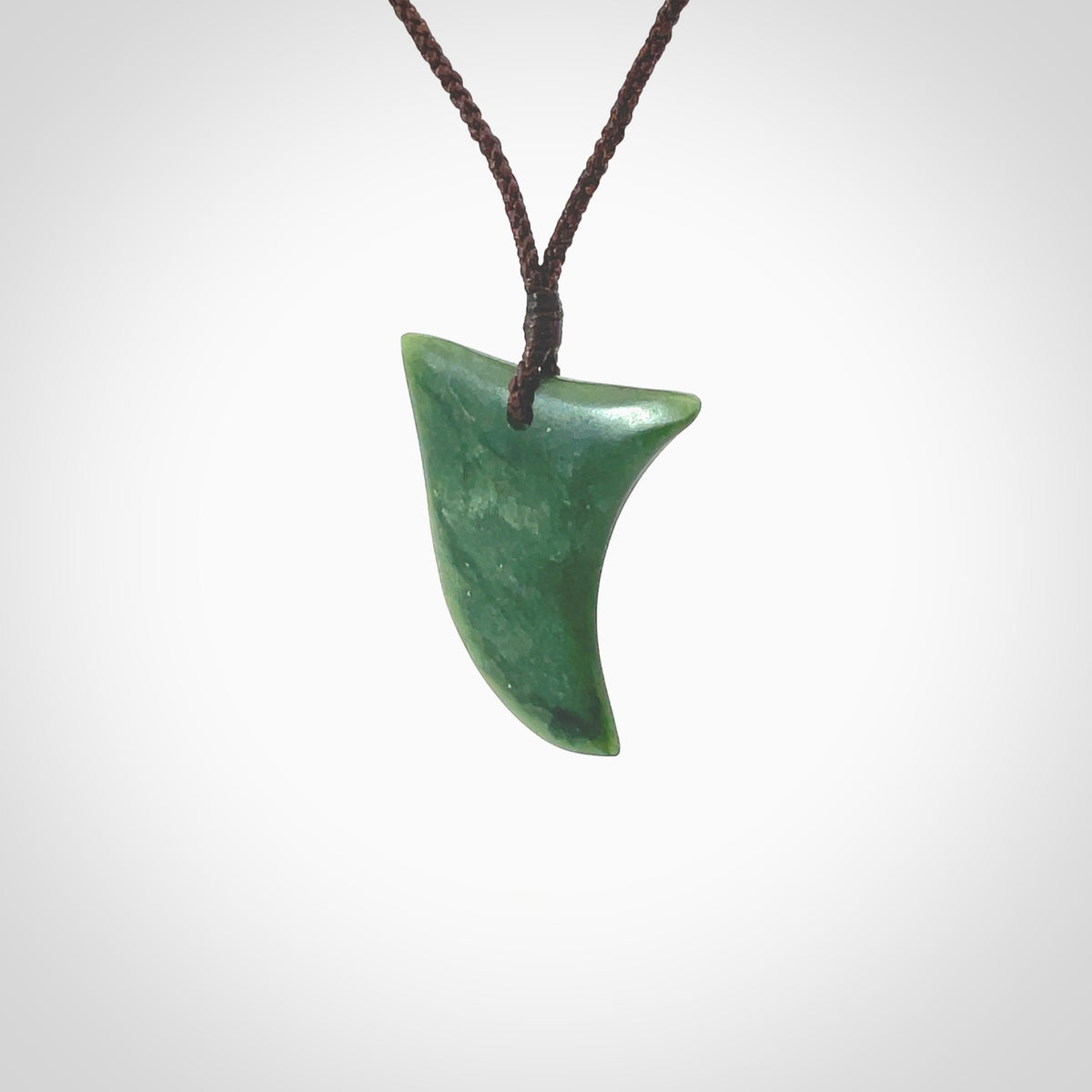 Hand carved pounamu drop pendant. Jade necklace hand made in New Zealand. A contemporary drop pendant carved from rare New Zealand jade. NZ Pacific jade jewellery for sale online. Provided with adjustable brown cord.