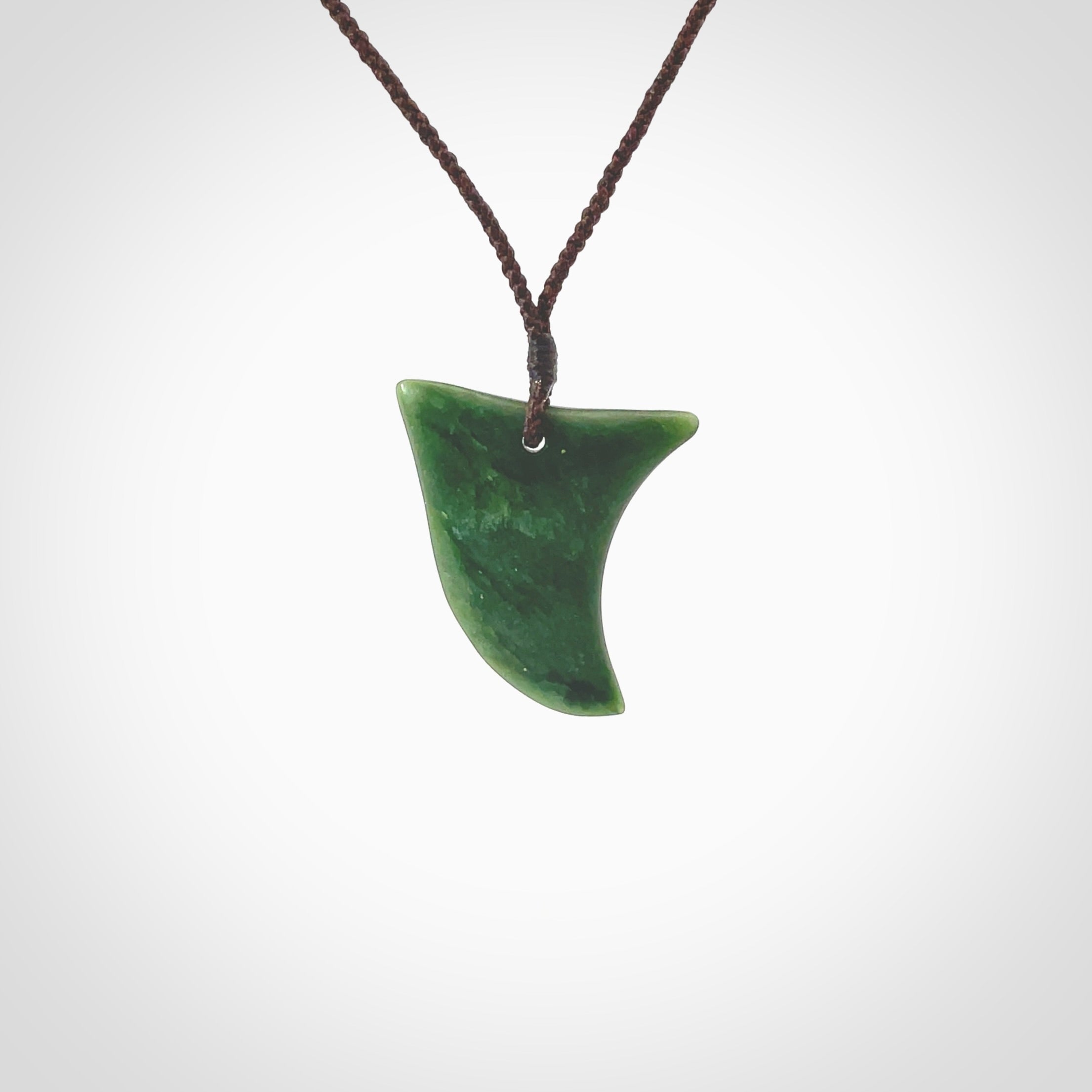 Hand carved pounamu drop pendant. Jade necklace hand made in New Zealand. A contemporary drop pendant carved from rare New Zealand jade. NZ Pacific jade jewellery for sale online. Provided with adjustable brown cord.