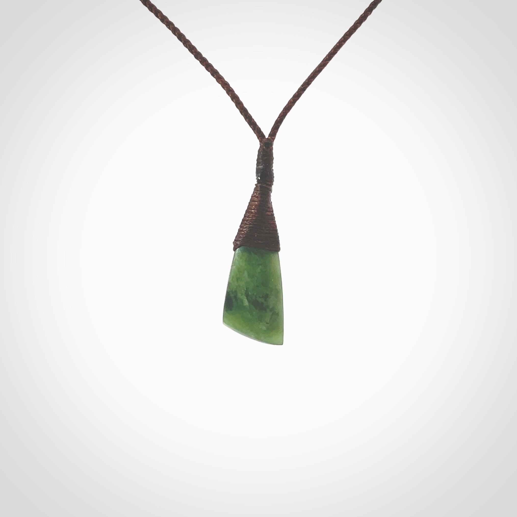 Hand carved pounamu drop pendant. Jade necklace hand made in New Zealand. A contemporary drop pendant carved from rare New Zealand jade. NZ Pacific jade jewellery for sale online. Provided with adjustable brown cord.