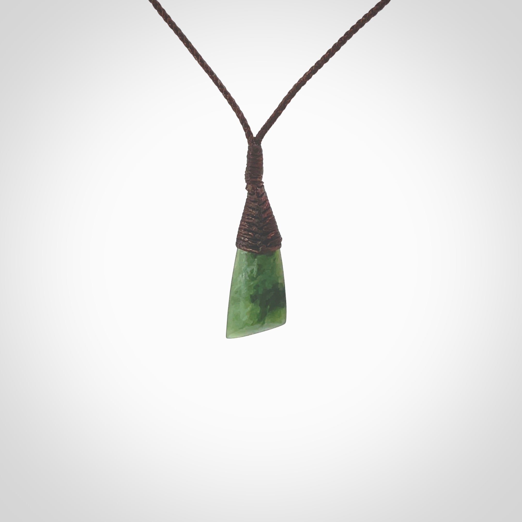 Hand carved pounamu drop pendant. Jade necklace hand made in New Zealand. A contemporary drop pendant carved from rare New Zealand jade. NZ Pacific jade jewellery for sale online. Provided with adjustable brown cord.