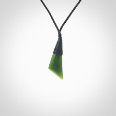 A lovely small sized New Zealand jade drop pendant. This piece is made from a semi-translucent jade and is a wonderful deep green colour. Carved by Ric Moor for NZ Pacific and delivered worldwide. Provided with an adjustable black cord.