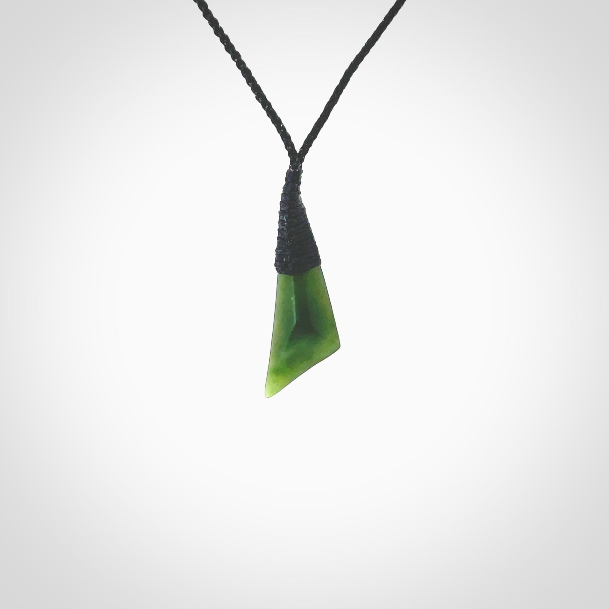 A lovely small sized New Zealand jade drop pendant. This piece is made from a semi-translucent jade and is a wonderful deep green colour. Carved by Ric Moor for NZ Pacific and delivered worldwide. Provided with an adjustable black cord.