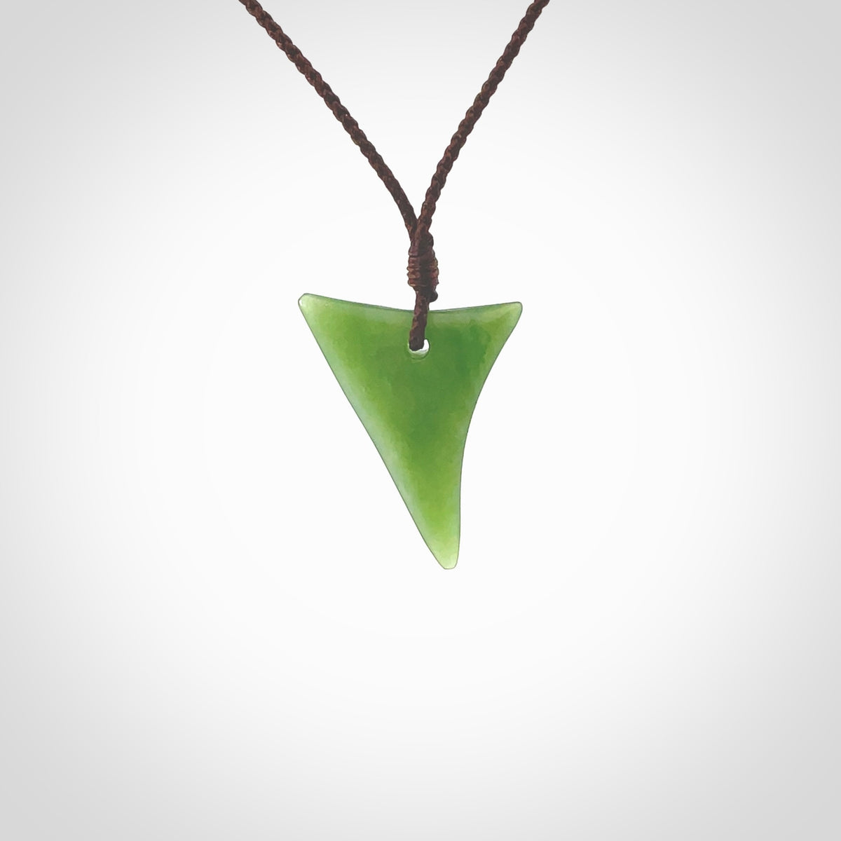 One only small sized New Zealand jade drop pendant. Hand carved in New Zealand by Ric Moor, jade artist, for NZ Pacific. Provided with adjustable brown cord.