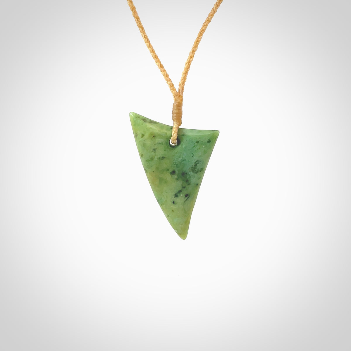 This is a lovely New Zealand Jade, pounamu drop pendant. Hand carved for us by Ric Moor. It is bound with an adjustable beige coloured cord which is length adjustable. Free worldwide shipping.