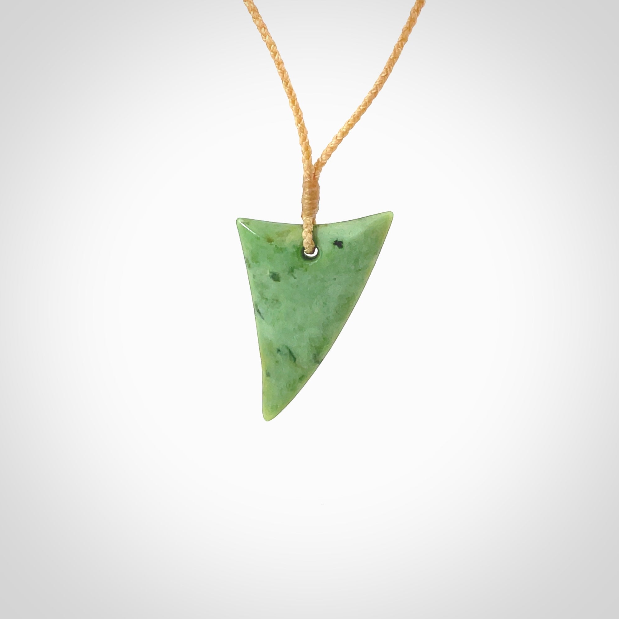 This is a lovely New Zealand Jade, pounamu drop pendant. Hand carved for us by Ric Moor. It is bound with an adjustable beige coloured cord which is length adjustable. Free worldwide shipping.