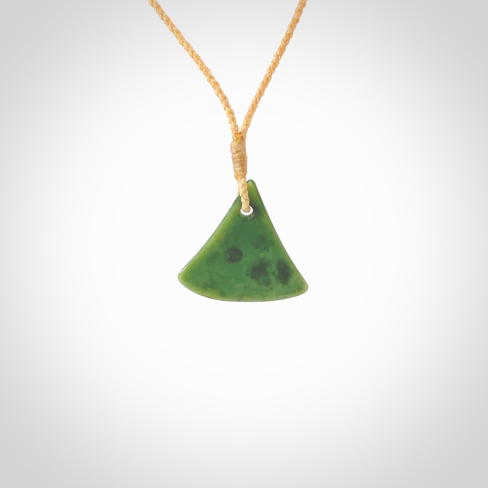 This is a lovely New Zealand Jade, pounamu drop pendant. Hand carved for us by Ric Moor. It is bound with an adjustable beige coloured cord which is length adjustable. Free worldwide shipping.